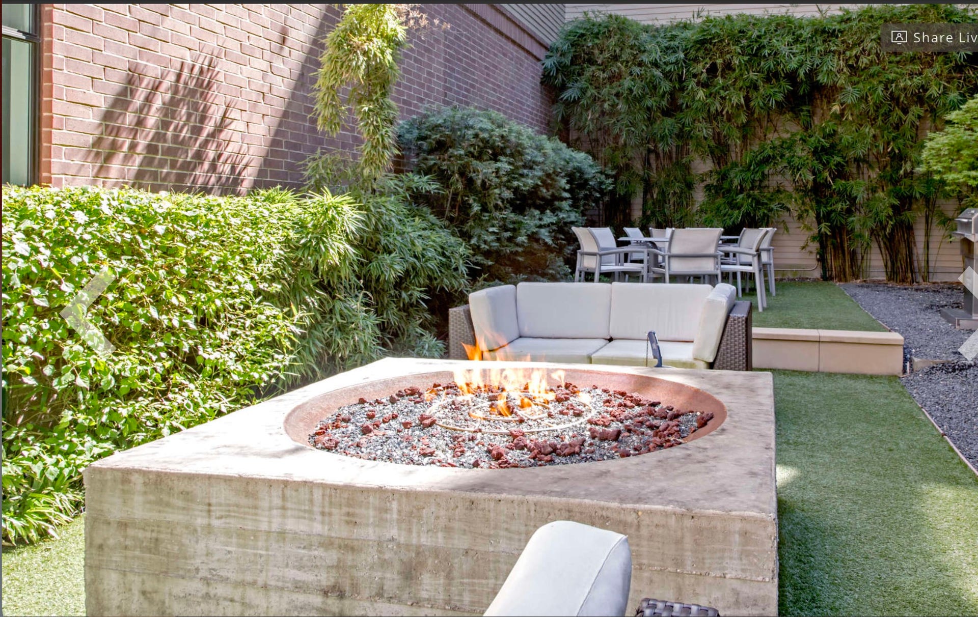 Tranquil outdoor courtyard featuring lush landscaping, comfortable lounge and dining areas, and a modern fire pit. A private retreat designed for relaxing, gathering, and enjoying the outdoors.