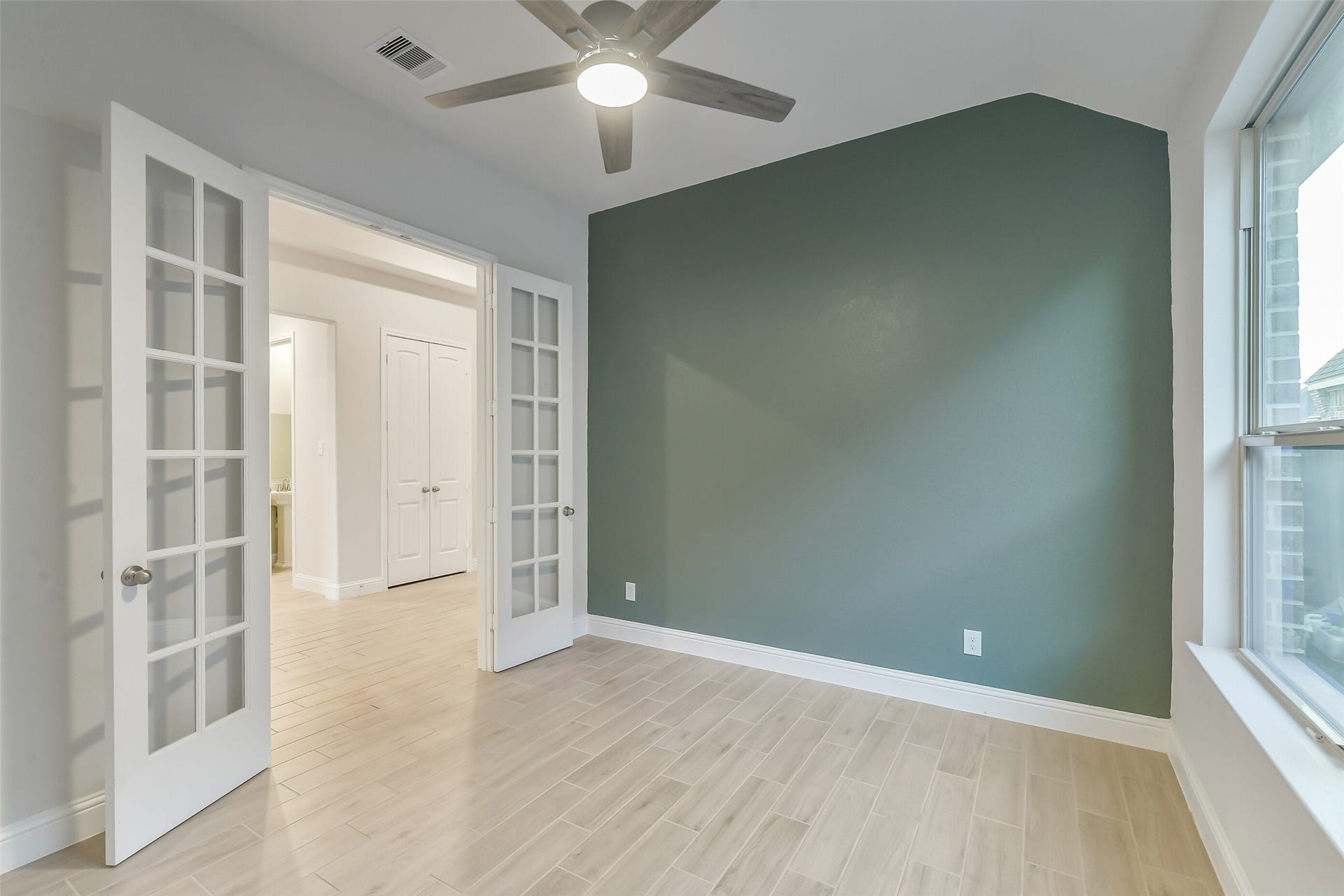 20330 Rose Gray Lane, Tomball, TX 77377 This home office or extra room features a gorgeous accent wall, ceiling fan, and glass paned French doors.