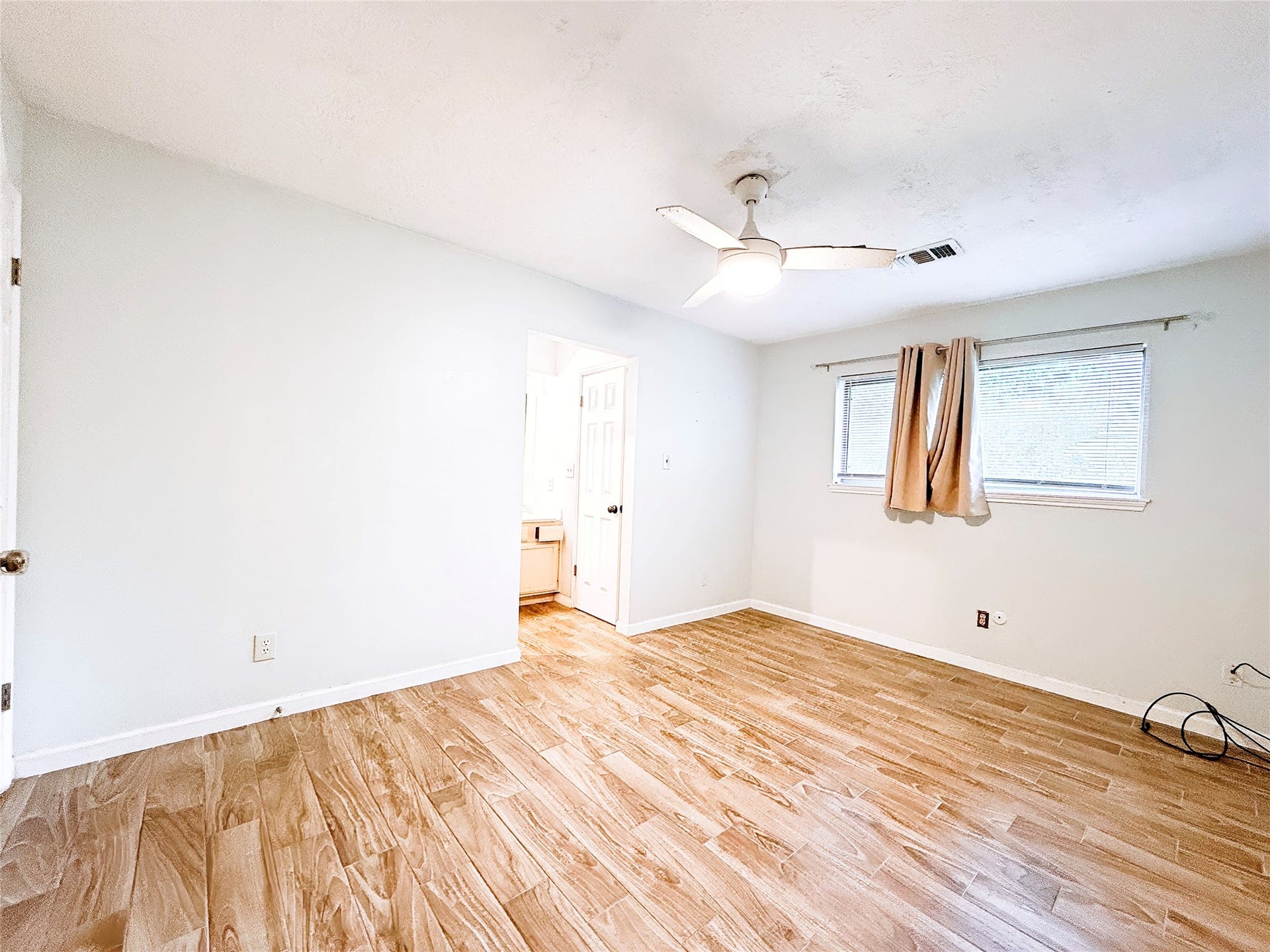 8116 Gulick Lane, Houston, TX 77075 Bright and spacious bedroom featuring wood-style flooring, a ceiling fan, and a convenient en-suite bathroom.
