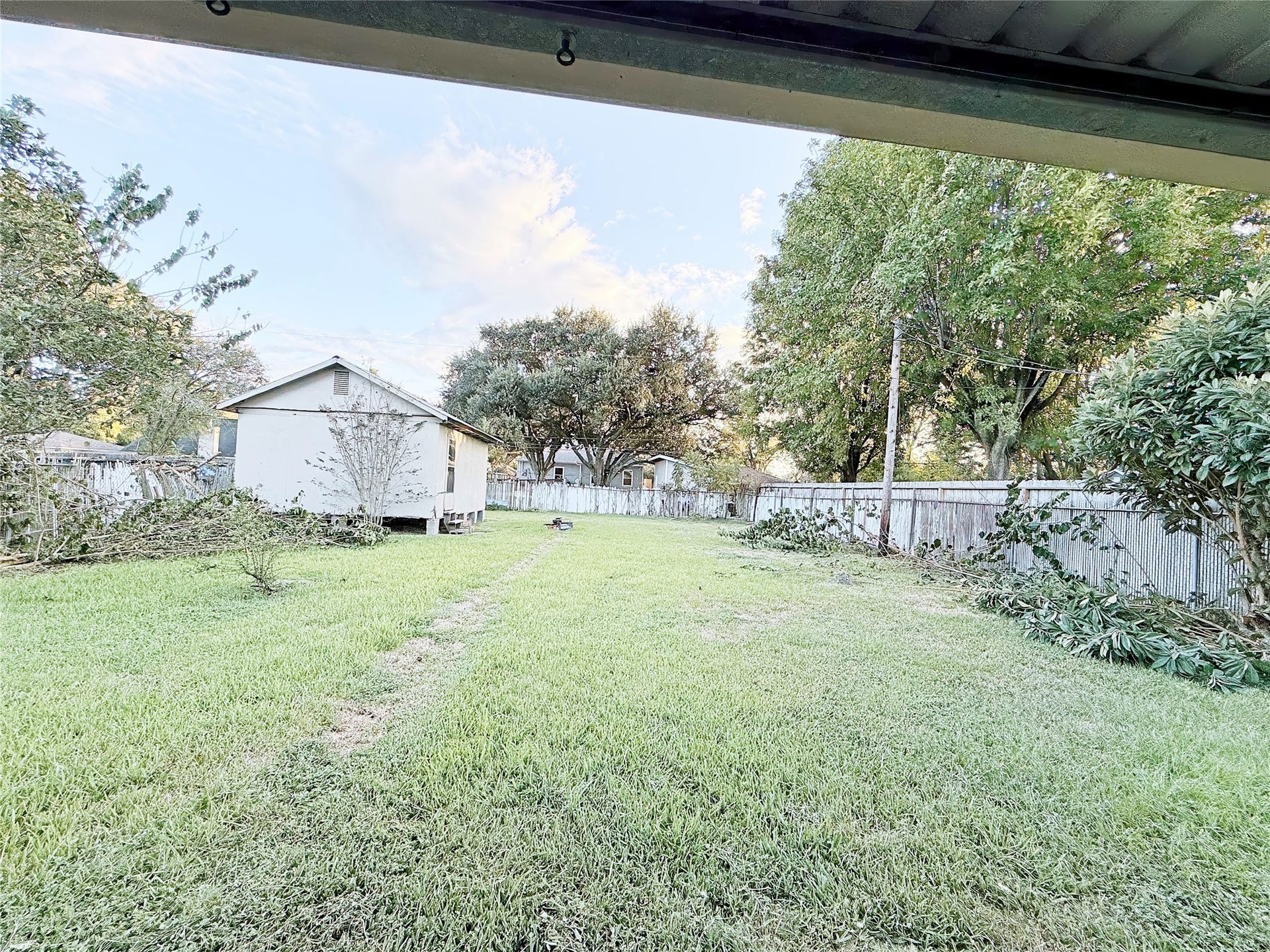 8116 Gulick Lane, Houston, TX 77075 Expansive backyard with lush greenery, mature trees, and a charming shed, perfect for gardening or outdoor activities.
