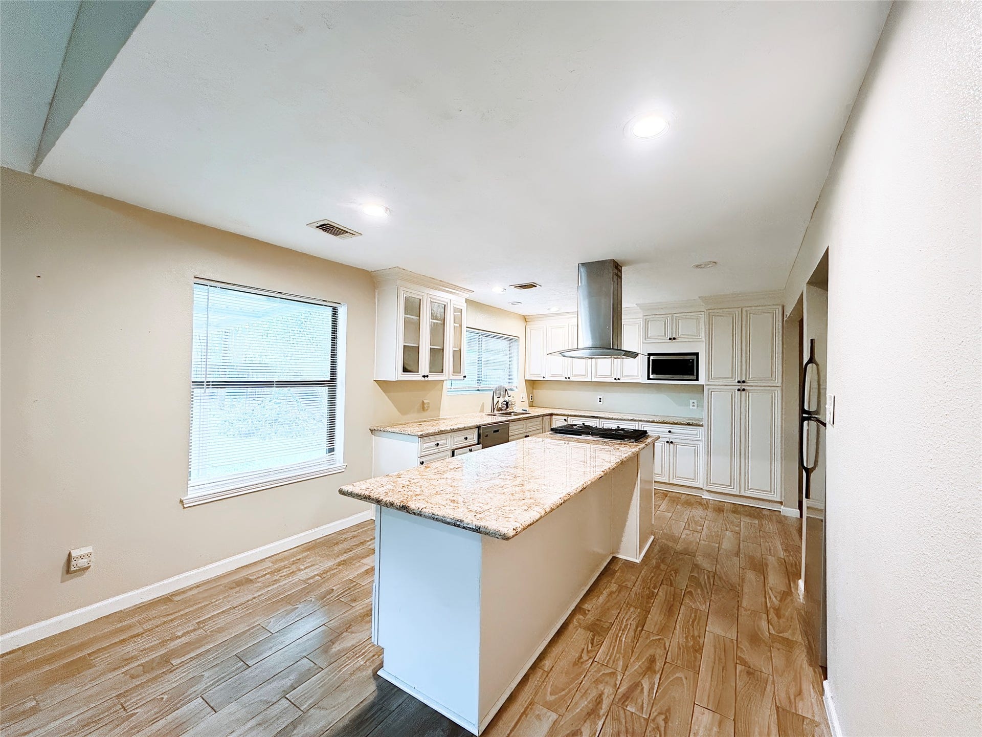 8116 Gulick Lane, Houston, TX 77075 Spacious kitchen with a large granite island, modern stainless steel appliances, and elegant cabinetry, all illuminated by ample natural light.