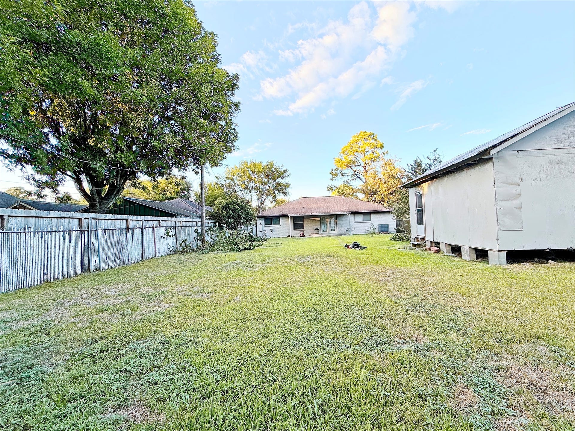 8116 Gulick Lane, Houston, TX 77075 Expansive backyard with lush grass, mature trees, and a charming ranch-style home offering ample outdoor space and privacy.