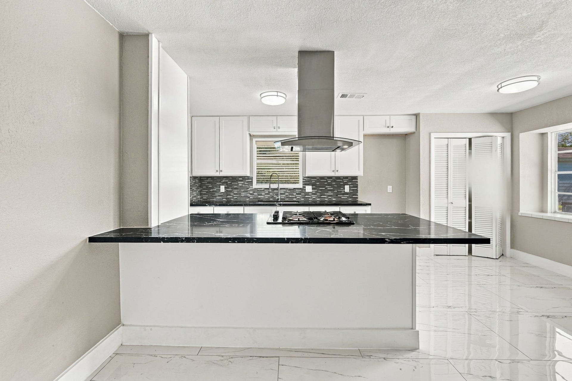 1023 Twinbrooke Drive, Houston, TX 77088 The kitchen island adds prep space, bar seating, and a polished focal point within the main living area. Virtually staged.