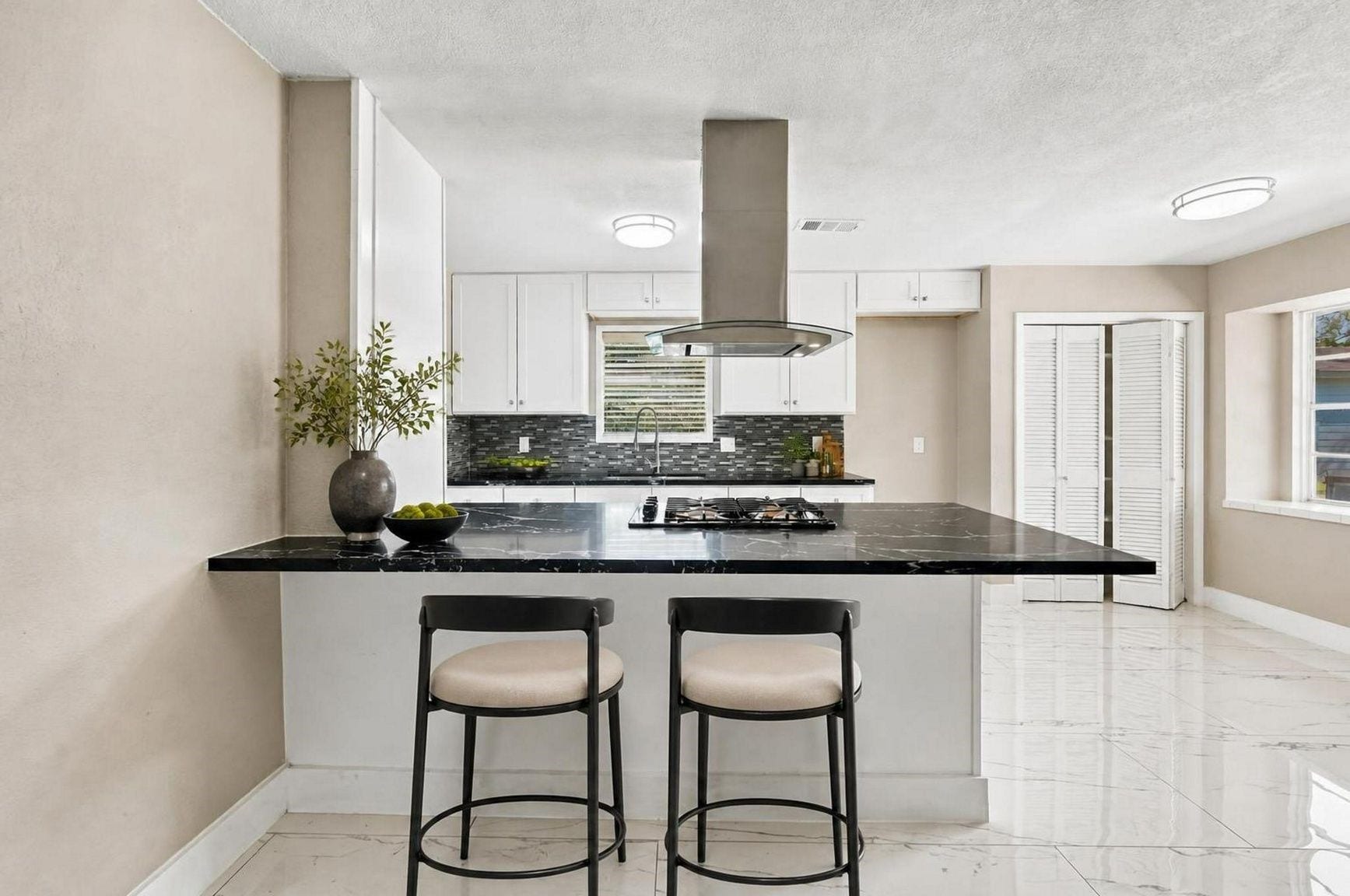 1023 Twinbrooke Drive, Houston, TX 77088 The kitchen opens with quartz counters, bar seating, bright finishes, and a crisp everyday layout. Virtually staged.