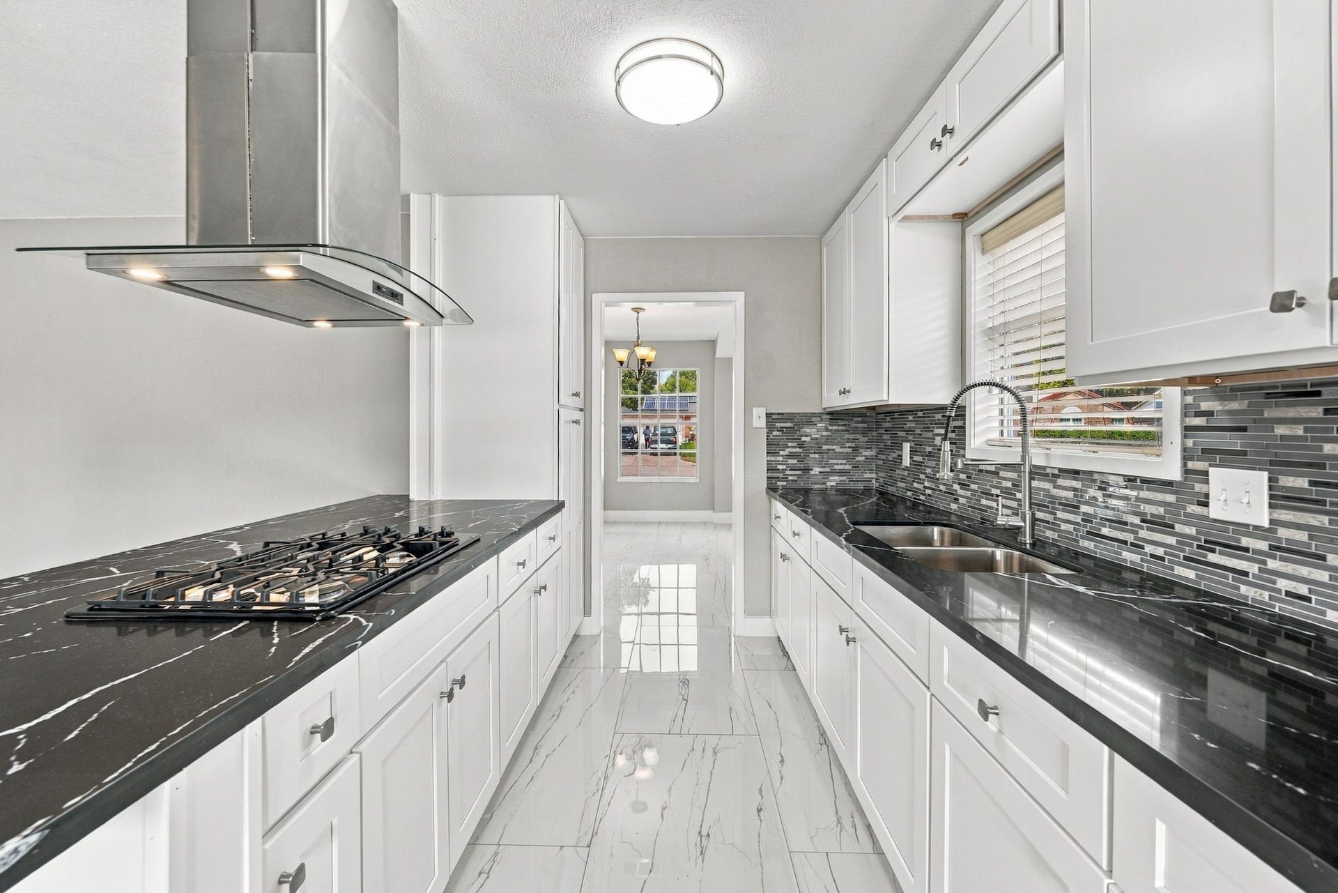 1023 Twinbrooke Drive, Houston, TX 77088 The gas cooktop and dark counter contrast create a sharp, functional cooking zone. Virtually staged.