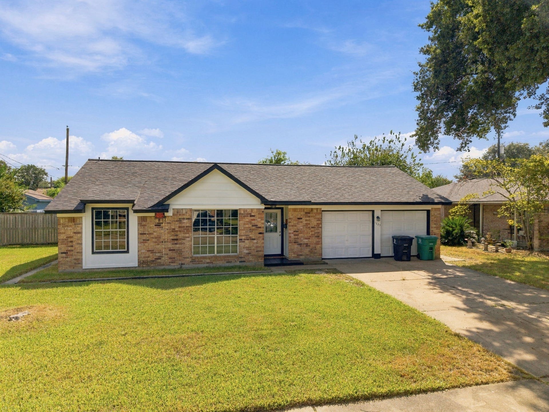 1023 Twinbrooke Drive, Houston, TX 77088 The daytime exterior highlights the homes brick elevation, green lawn, and wide driveway approach. Virtually staged.