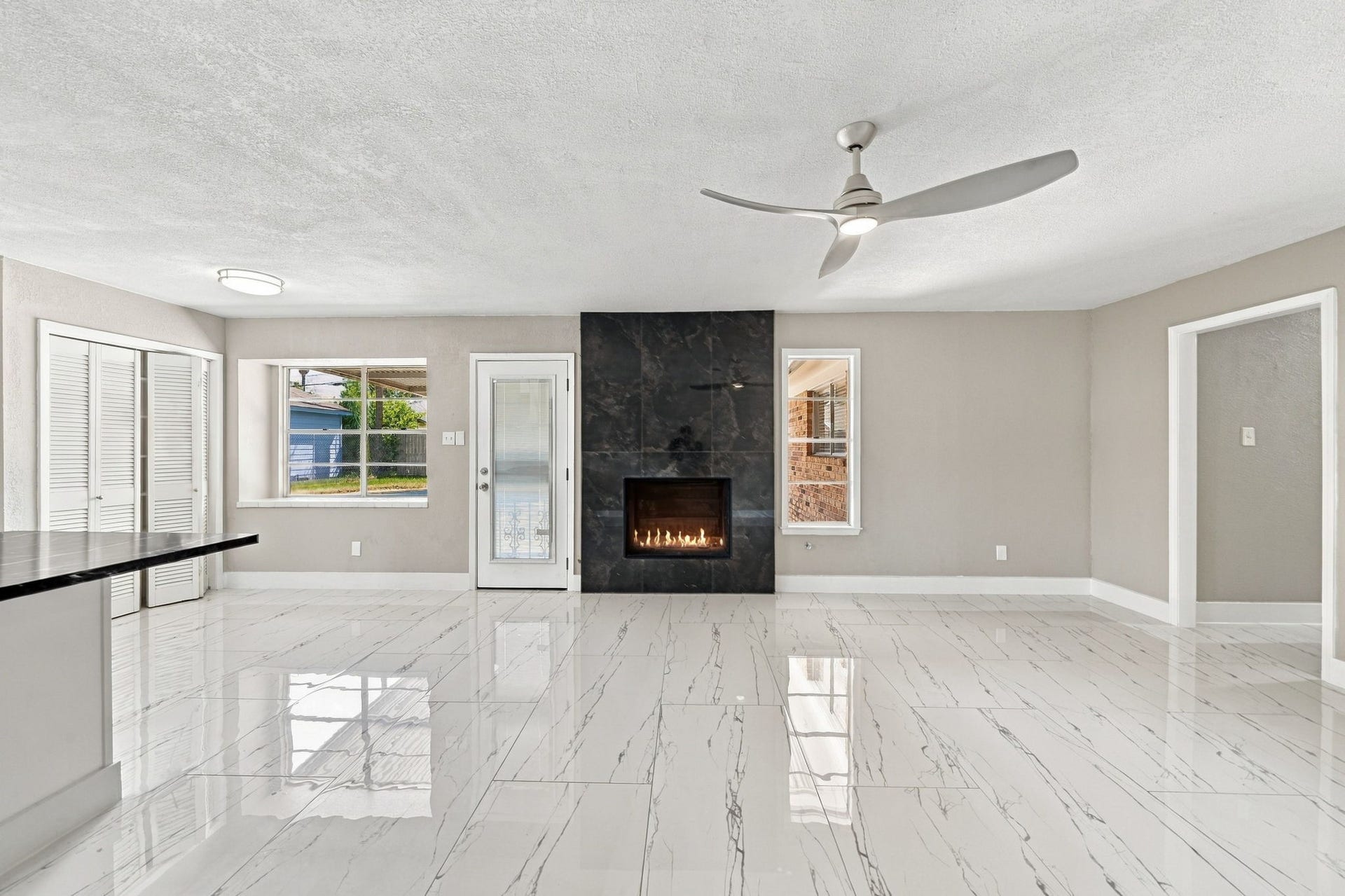 1023 Twinbrooke Drive, Houston, TX 77088 This view shows the family rooms scale, pool-facing light, and open connection to the kitchen. Virtually staged.