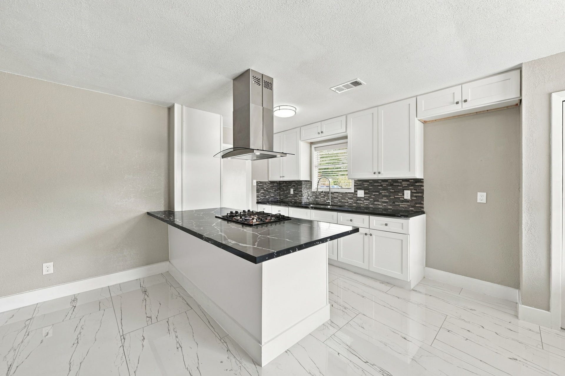 1023 Twinbrooke Drive, Houston, TX 77088 This angle showcases the island, bright finishes, and open connection into the surrounding rooms. Virtually staged.