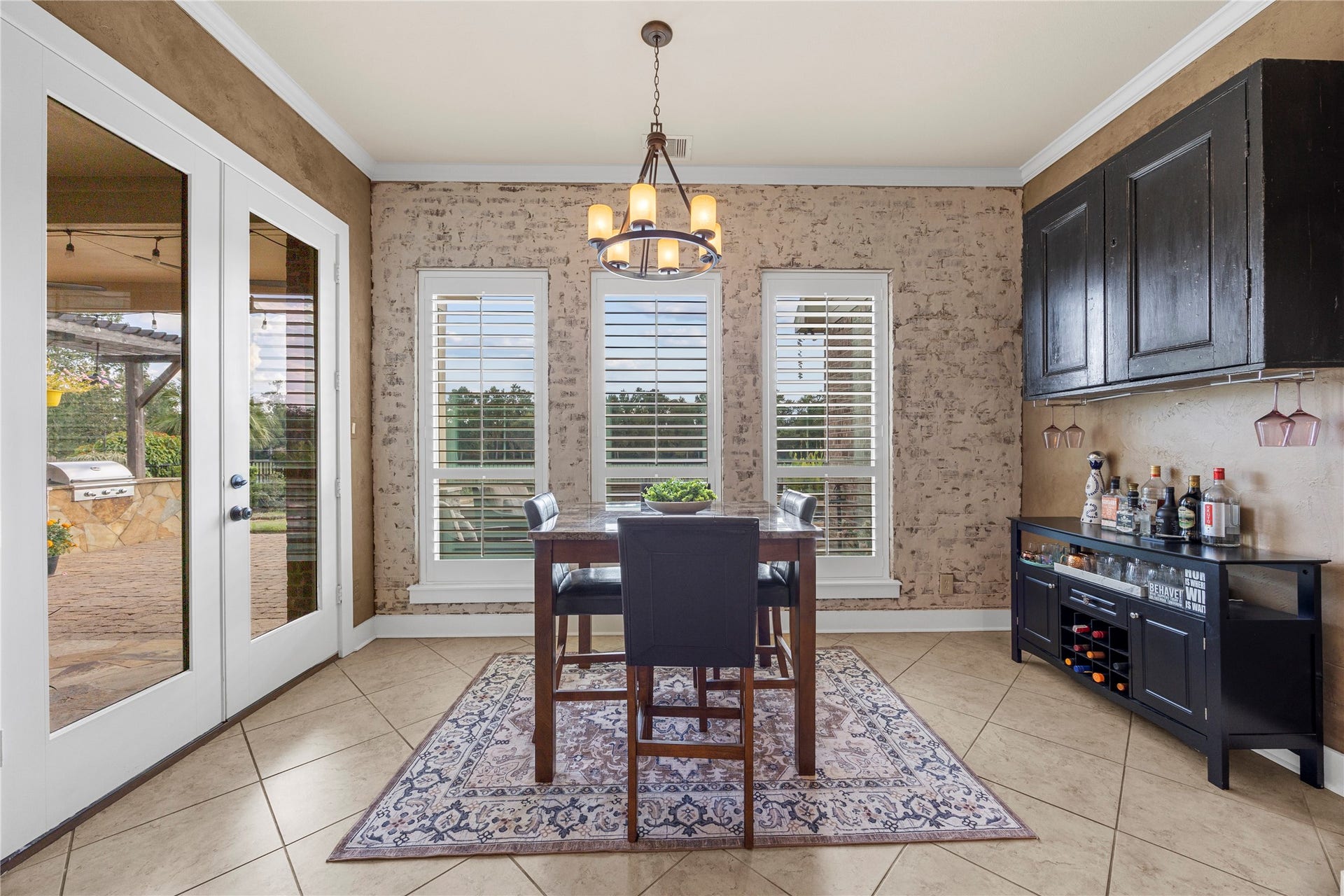 18515 Duke Lake Drive, Spring, TX 77388 Charming breakfast area featuring decorative brick accents, plantation shutters, statement lighting, and French doors leading to the outdoor living space.