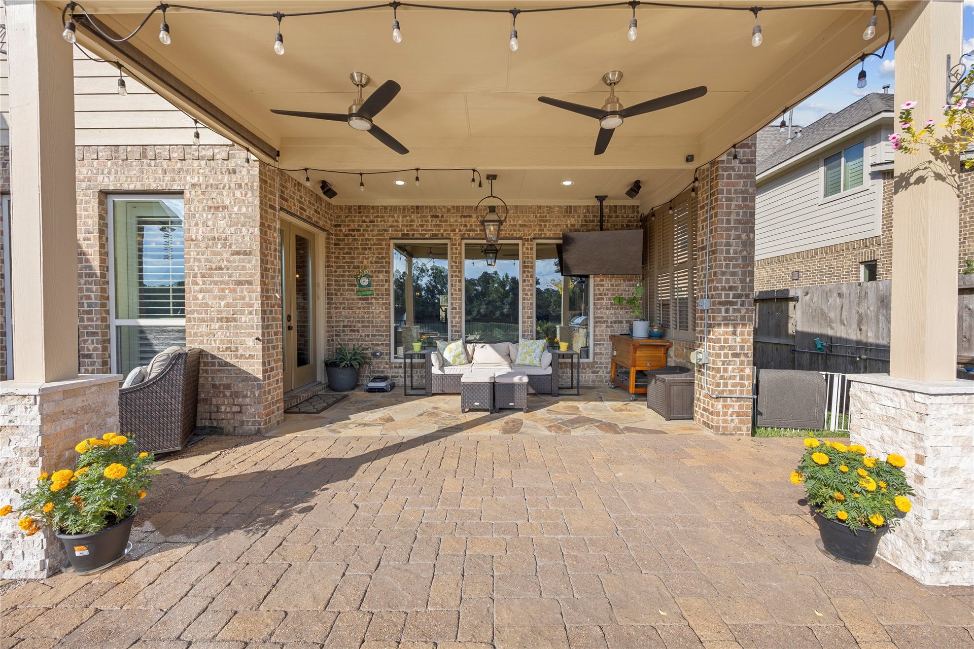 18515 Duke Lake Drive, Spring, TX 77388 Spacious covered patio featuring dual ceiling fans, string lighting, recessed lighting, and a comfortable seating area for year-round enjoyment.