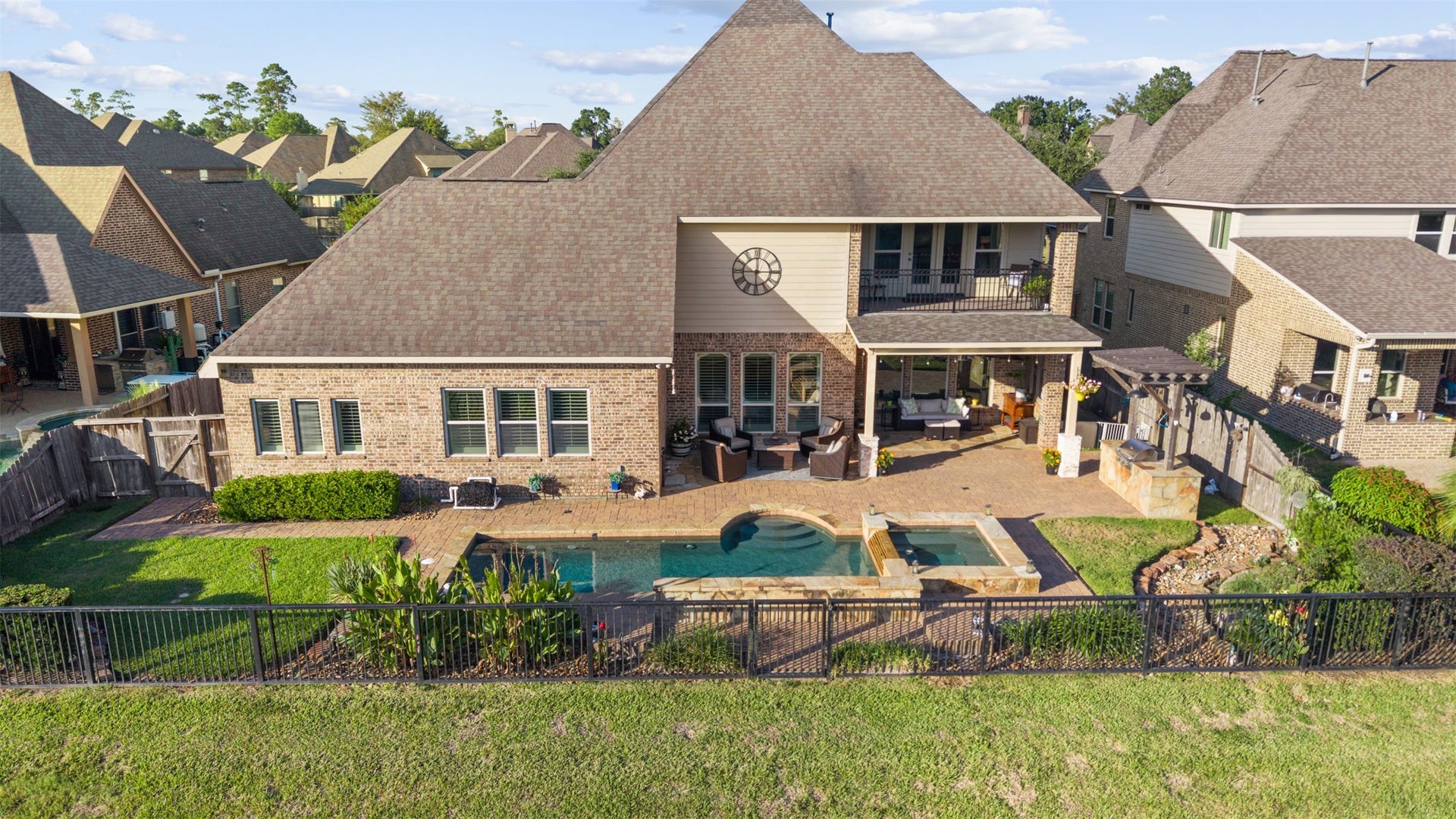 18515 Duke Lake Drive, Spring, TX 77388 Elevated rear view highlighting the home's impressive architecture, second-story balcony, covered patio, outdoor kitchen, pool, and spa.