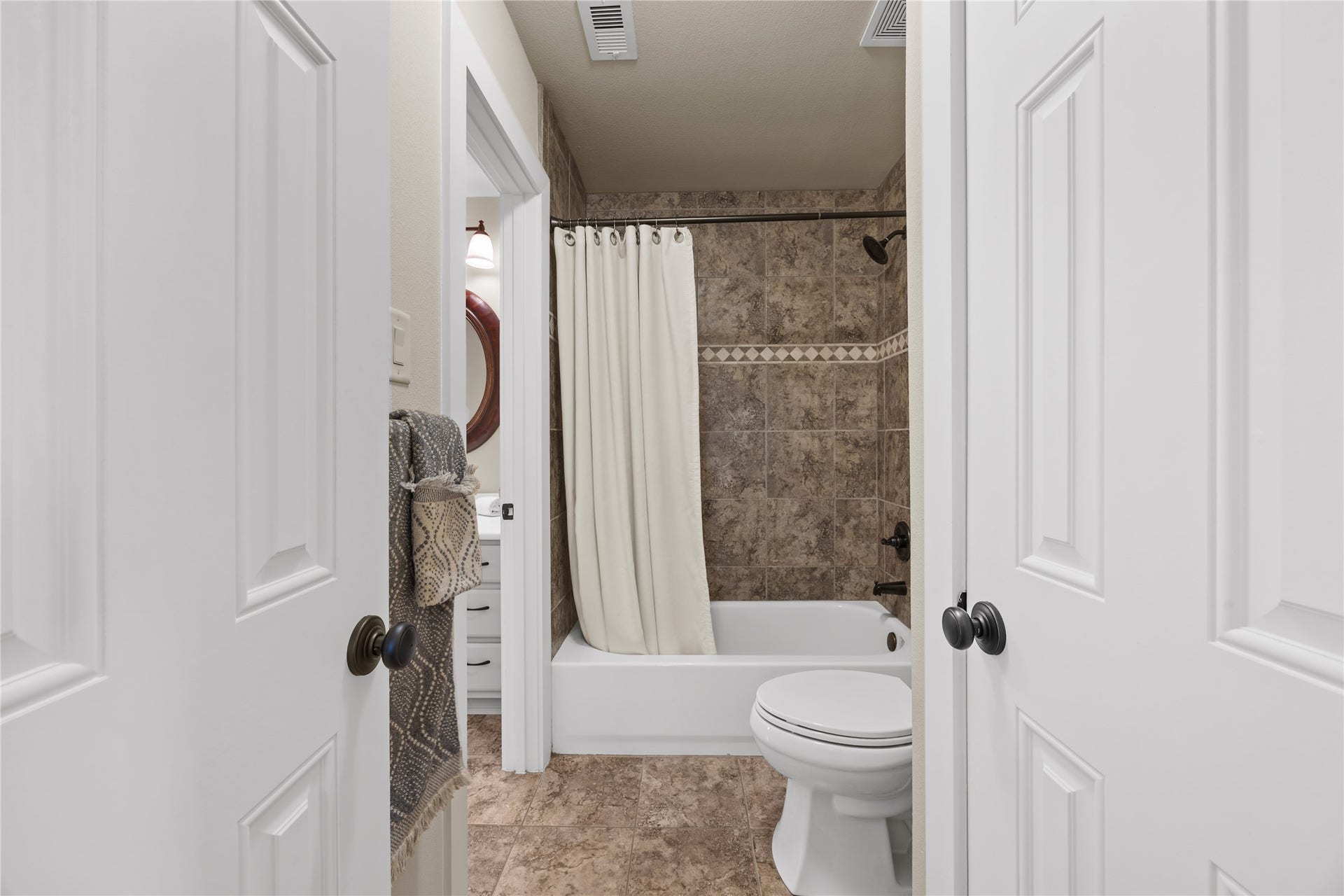 18515 Duke Lake Drive, Spring, TX 77388 Convenient upstairs bathroom featuring a tub/shower combination with decorative tile surround and neutral finishes.