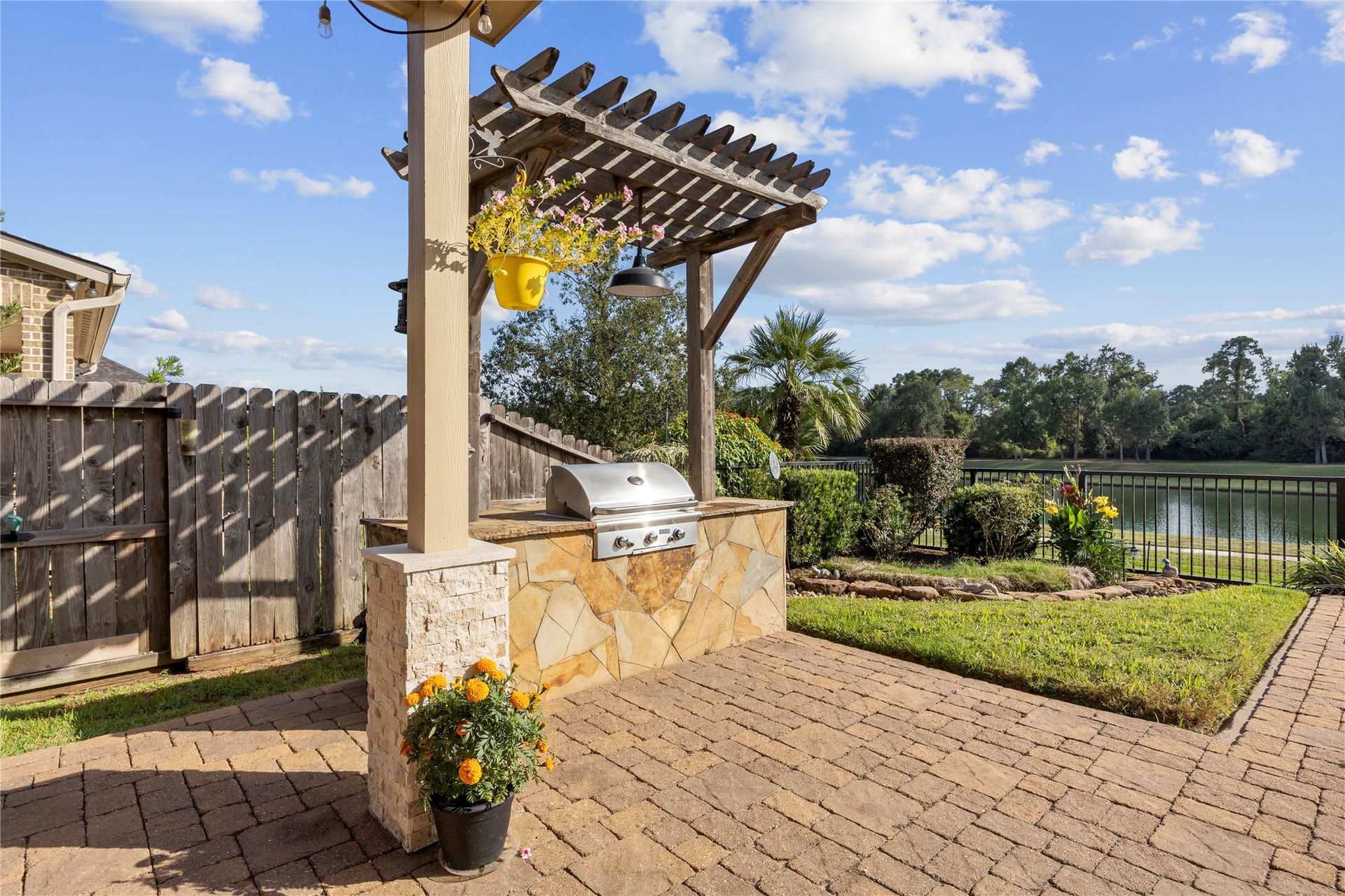 18515 Duke Lake Drive, Spring, TX 77388 Built-in outdoor grill with stone surround and wooden pergola, creating the perfect setting for backyard cookouts and entertaining.