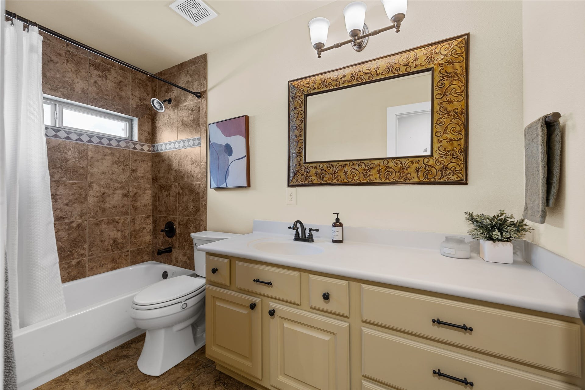 18515 Duke Lake Drive, Spring, TX 77388 Spacious secondary bathroom featuring a tub/shower combination with decorative tile accents, generous vanity counter space, and cabinet storage.