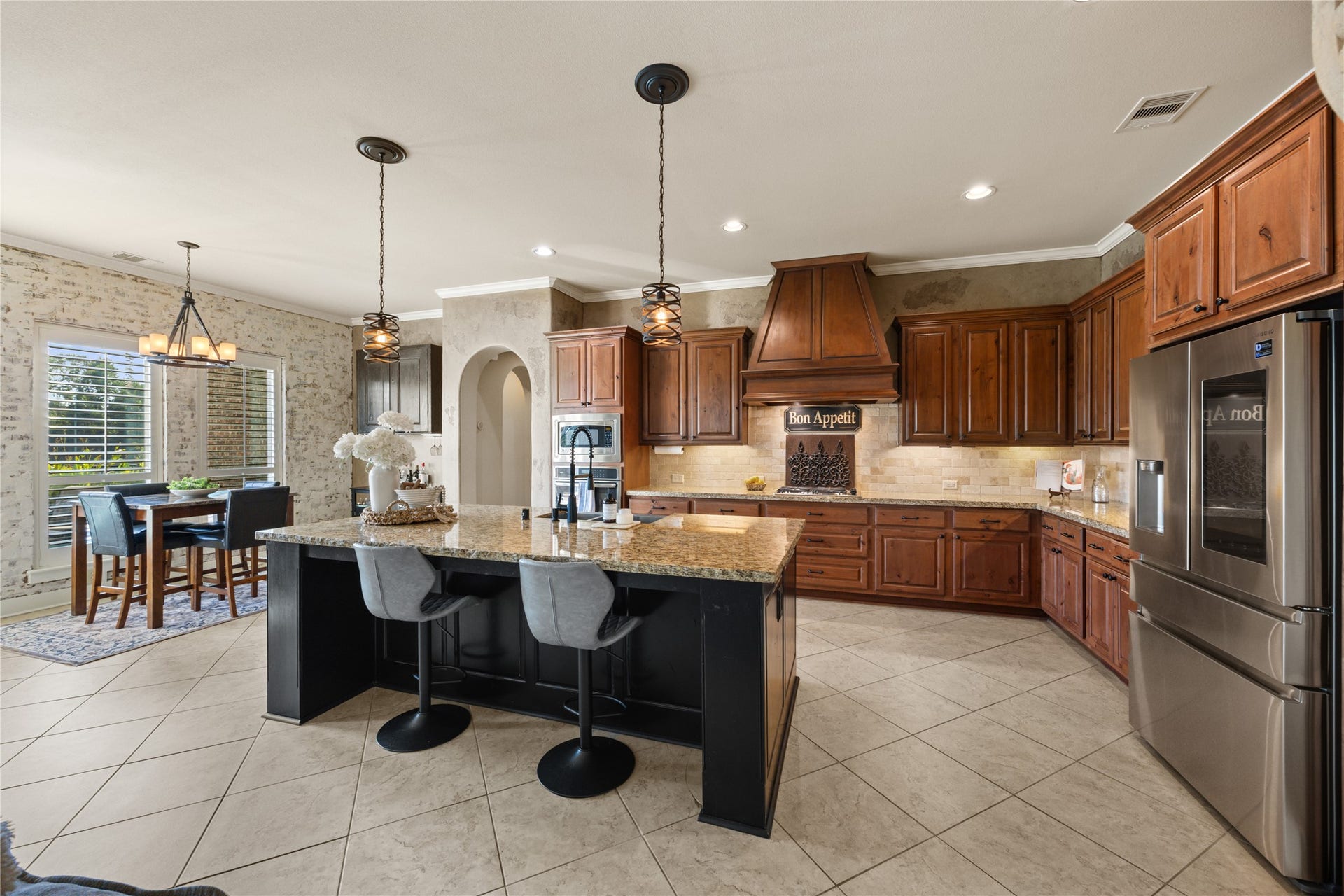 18515 Duke Lake Drive, Spring, TX 77388 Beautifully designed kitchen opens to the breakfast area, featuring a large center island, rich wood cabinetry, granite countertops, and abundant natural light.