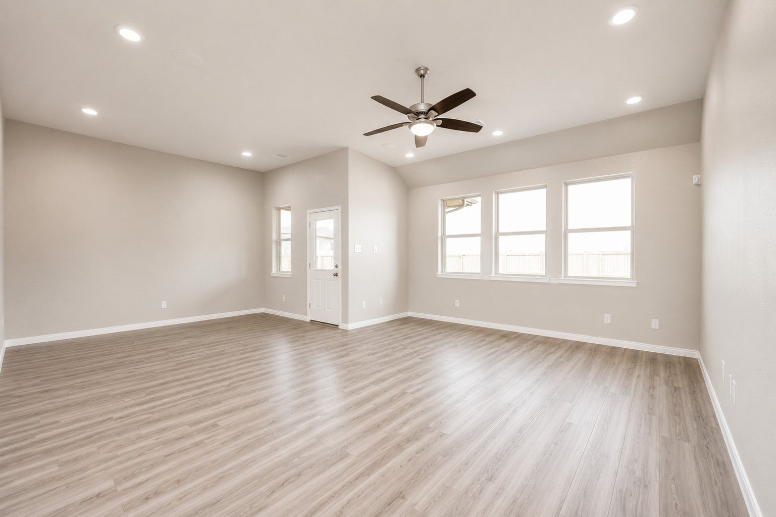 1311 Bonnerjee Drive, Crosby, TX 77532 Spacious view of the open concept living and dining areas, featuring high ceilings, abundant natural light, and beautiful wood look flooring