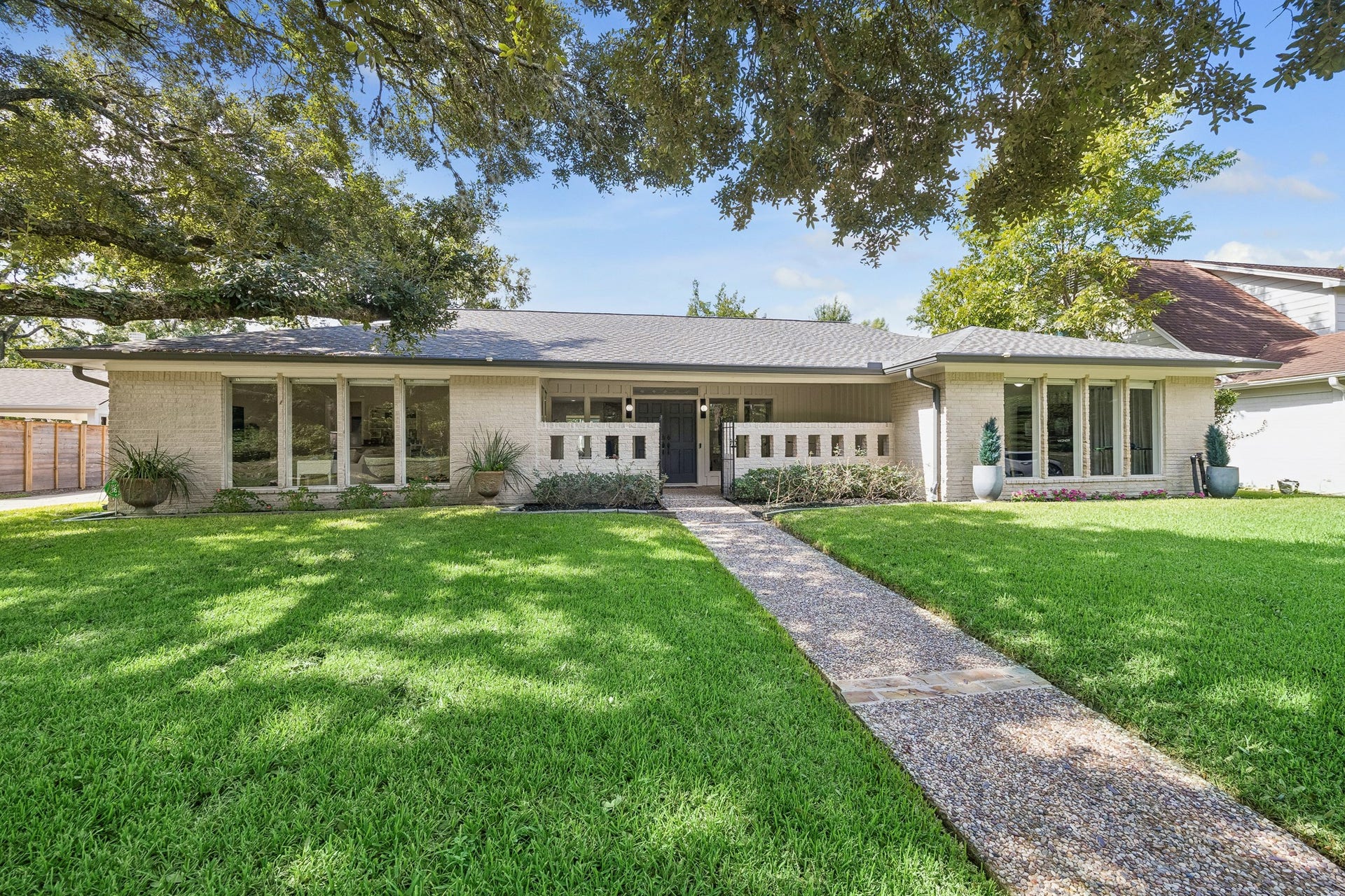 12314 Honeywood Trail, Houston, TX 77077 The oak tree shades the front lawn nicely, while the floor to ceiling windows allow natural light to flood the home.