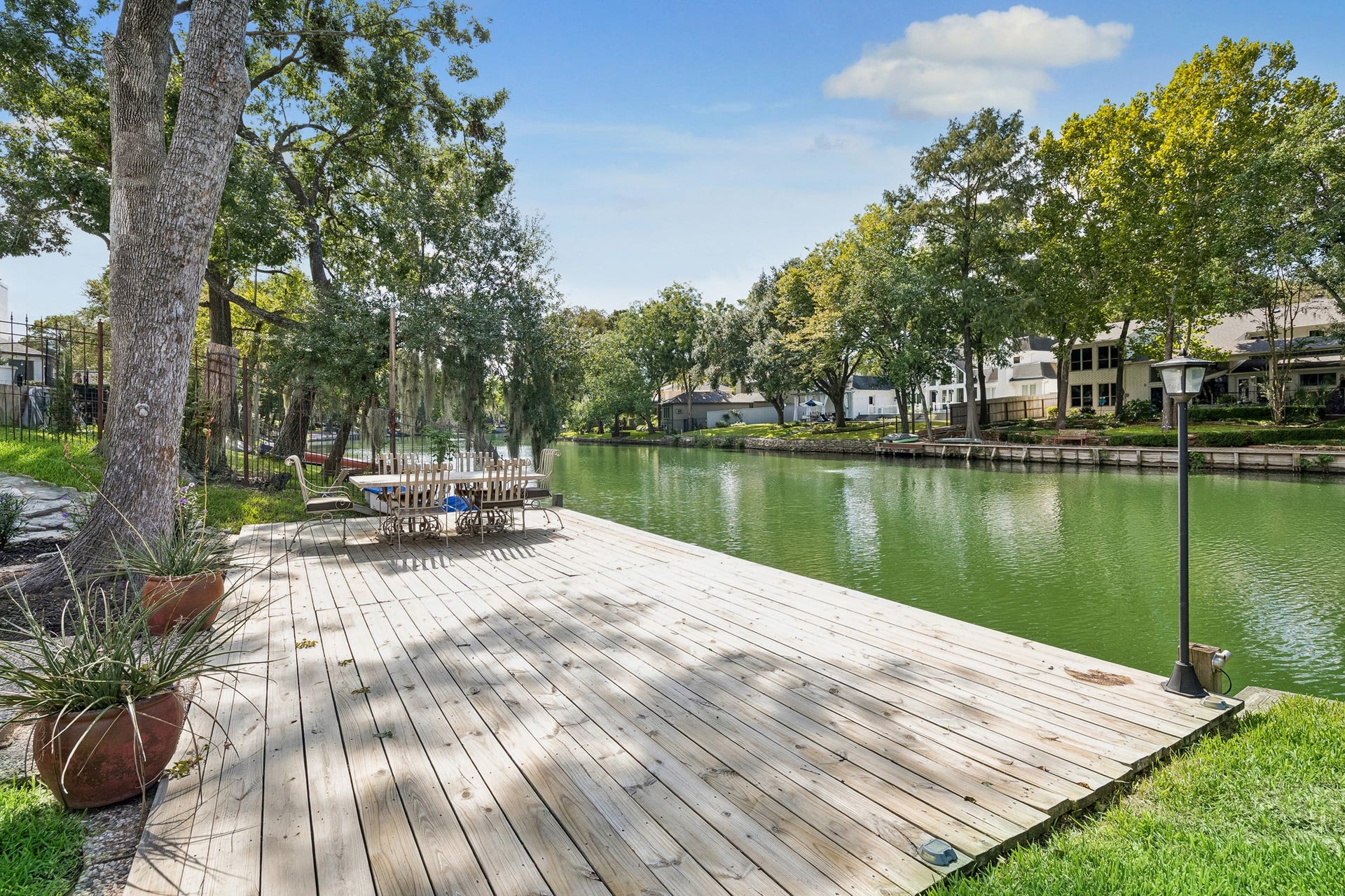 12314 Honeywood Trail, Houston, TX 77077 An expansive wood deck extends to the water's edge, offering a wonderful setting for outdoor dining, relaxing, and entertaining, with a serene backdrop.
