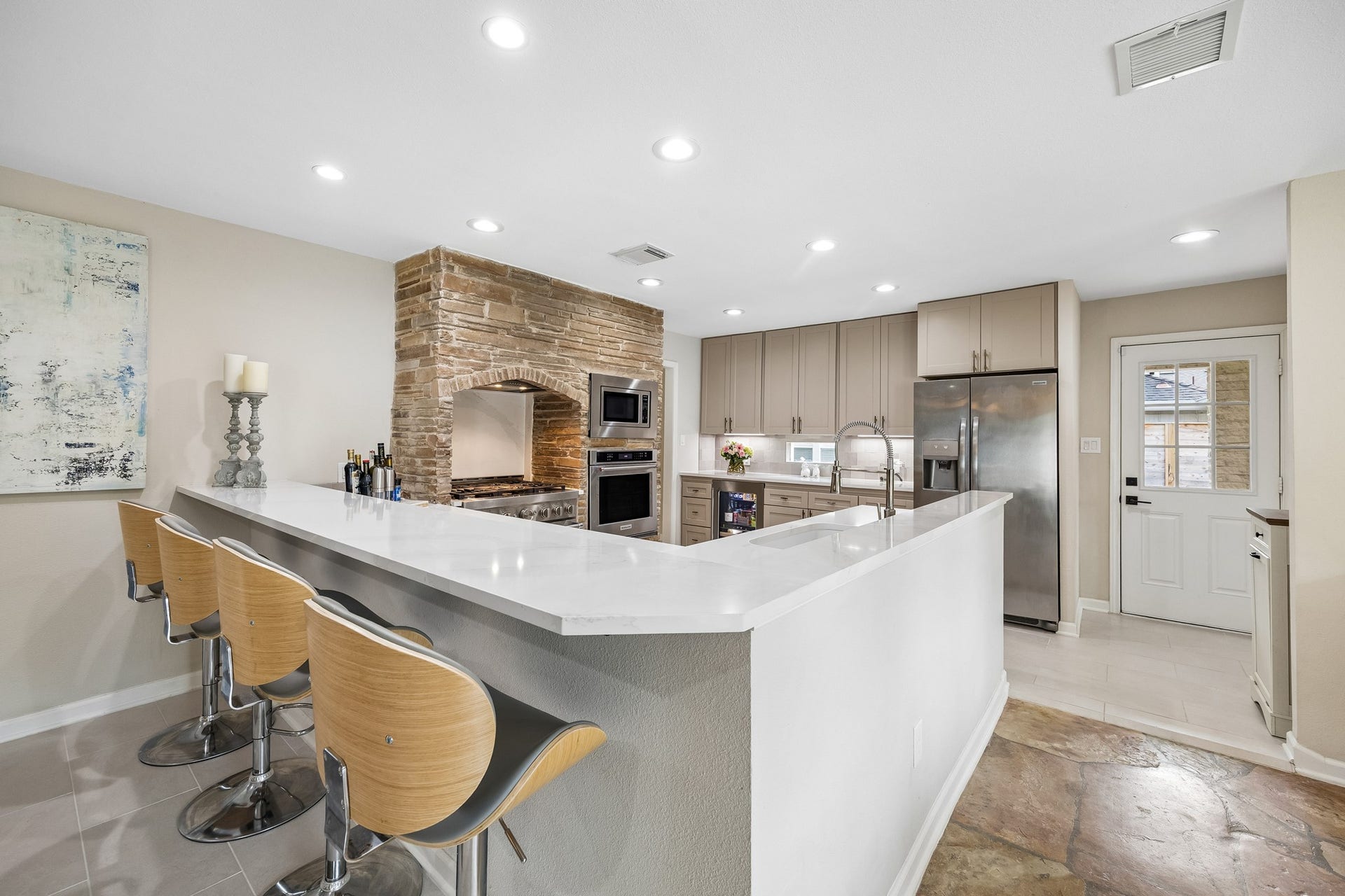 12314 Honeywood Trail, Houston, TX 77077 Neutral painted cabinetry spans the back wall of the kitchen, offering abundant storage, while the built-in wine refrigerator adds convenience for entertaining.