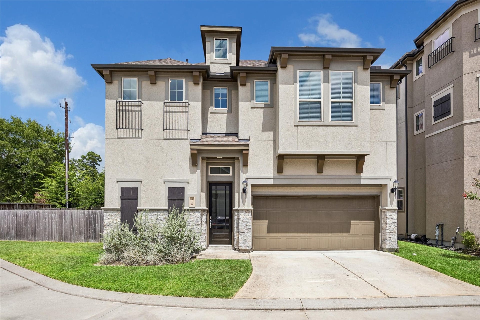 Striking traditional architecture with stone accents, manicured landscaping, and an attached two-car garage.