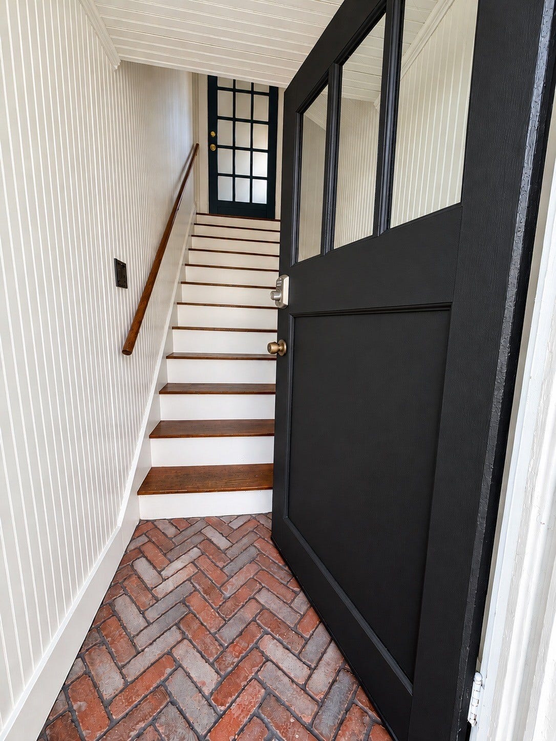 914.5 W Melwood Street, Houston, TX 77009 Fully enclosed private entry staircase with classic wood treads, beadboard detailing, and a dedicated exterior entrance.