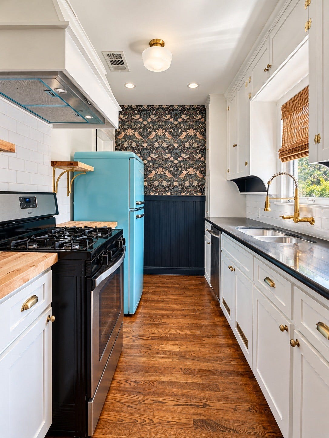 914.5 W Melwood Street, Houston, TX 77009 Updated kitchen with retro-inspired turquoise refrigerator, statement wallpaper, brass accents, and beautiful cabinetry.