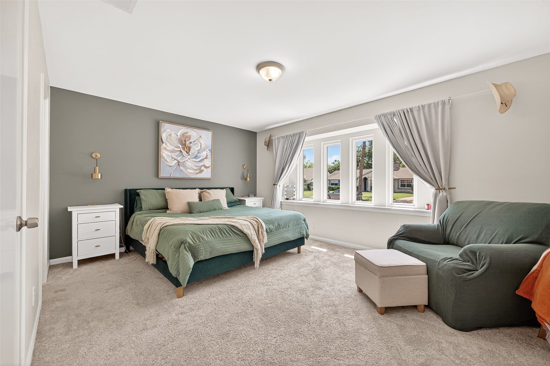 2610 Teague Road, Houston, TX 77080 This spacious primary retreat features a cozy carpeted floor, incredible windows with plenty of natural light, and a calming color palette. Ideal for relaxation and comfort.
