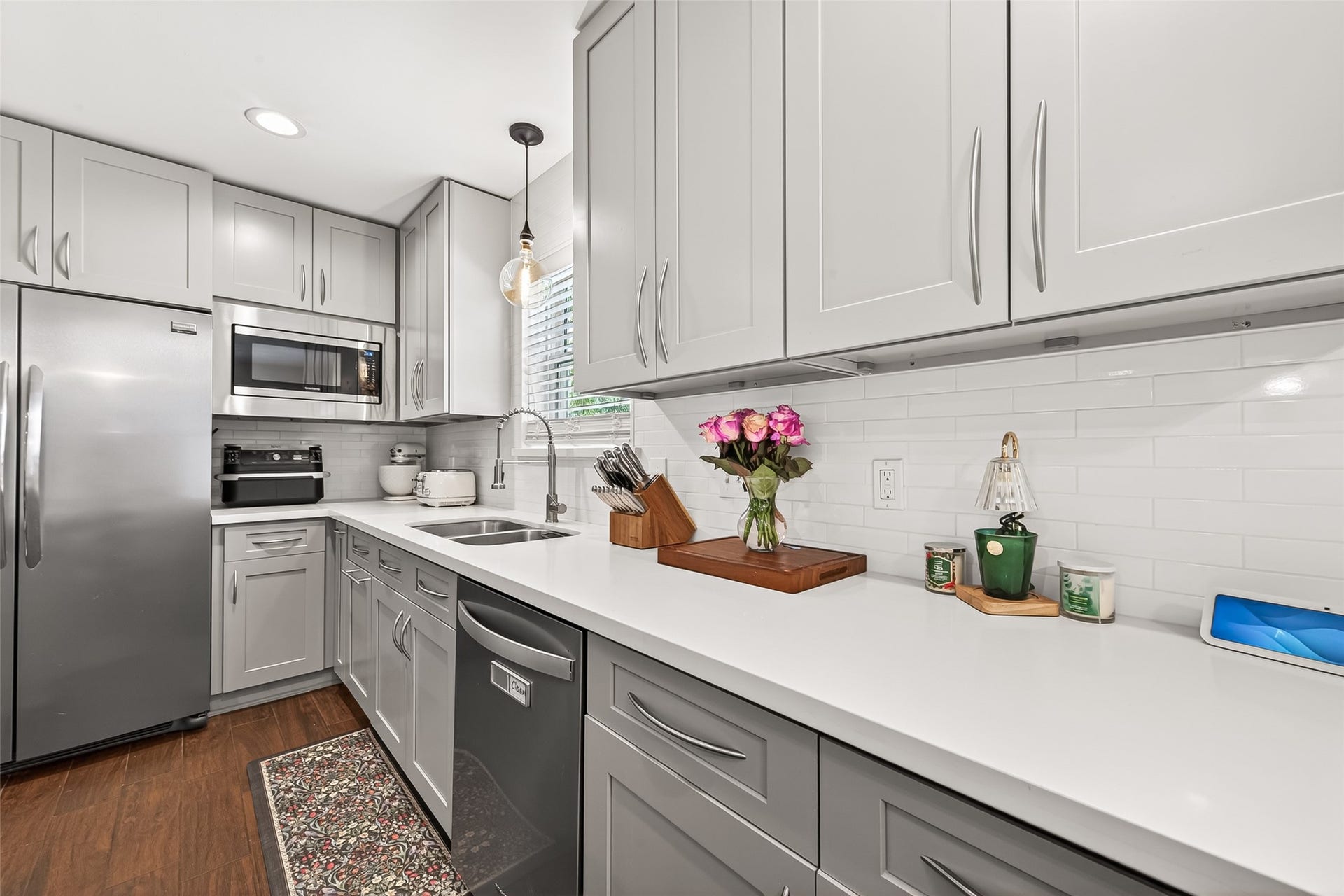 2610 Teague Road, Houston, TX 77080 This kitchen features sleek gray cabinetry, stainless steel appliances, and a bright white subway tile backsplash. The space is modern and well-lit, with ample counter space and a clean, contemporary design.