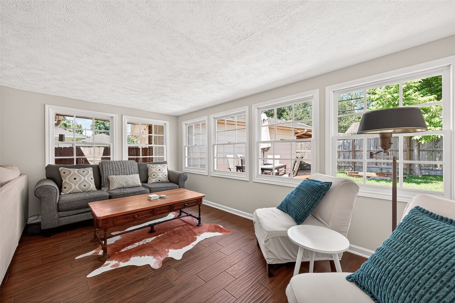 2610 Teague Road, Houston, TX 77080 Still part of the family room, this cozy sunroom area features large windows for ample natural light, warm flooring, and comfortable seating, offering a relaxing view of the backyard.