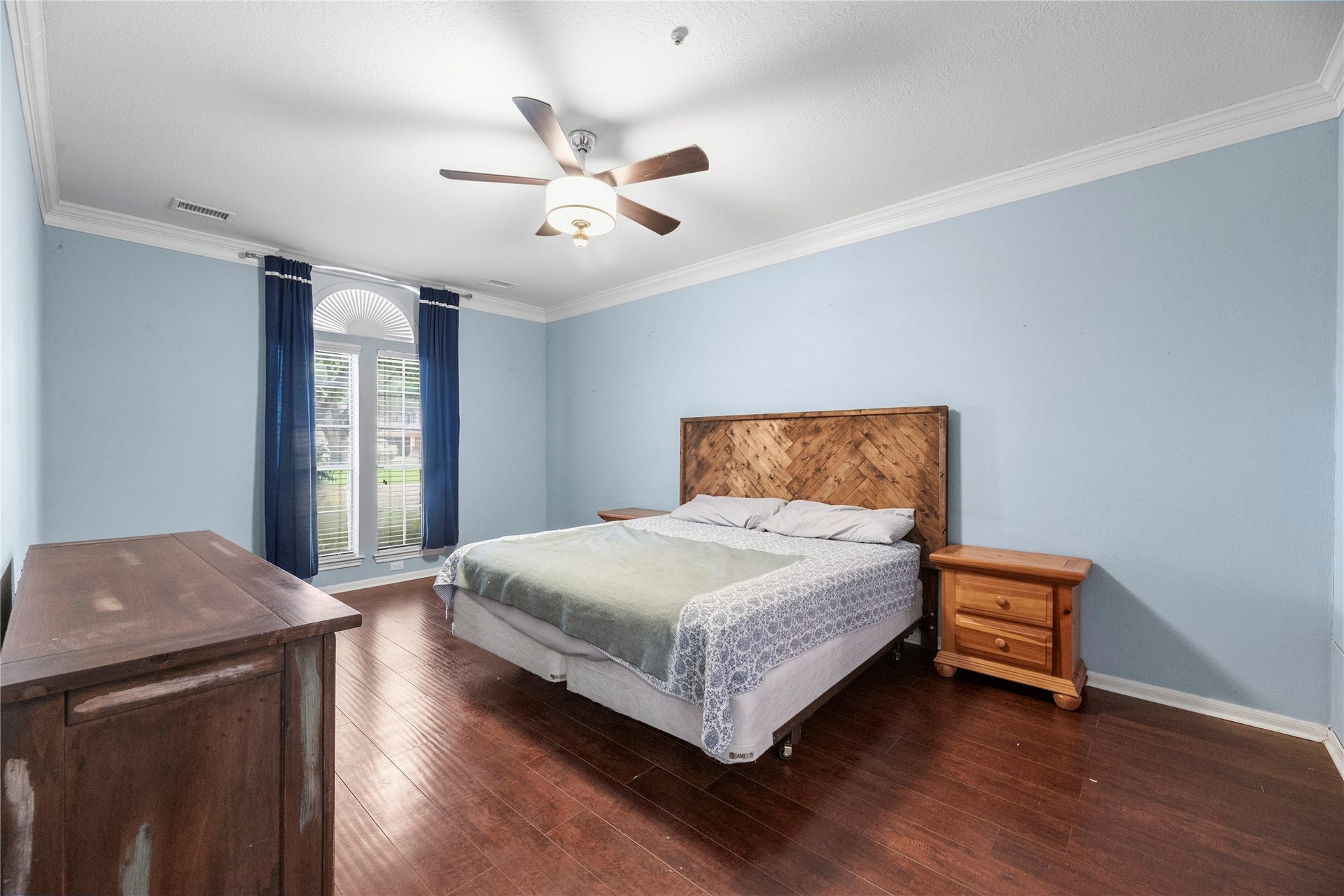 Downstairs primary bedroom features crown molding, ceiling fan and an en-suite bathroom.