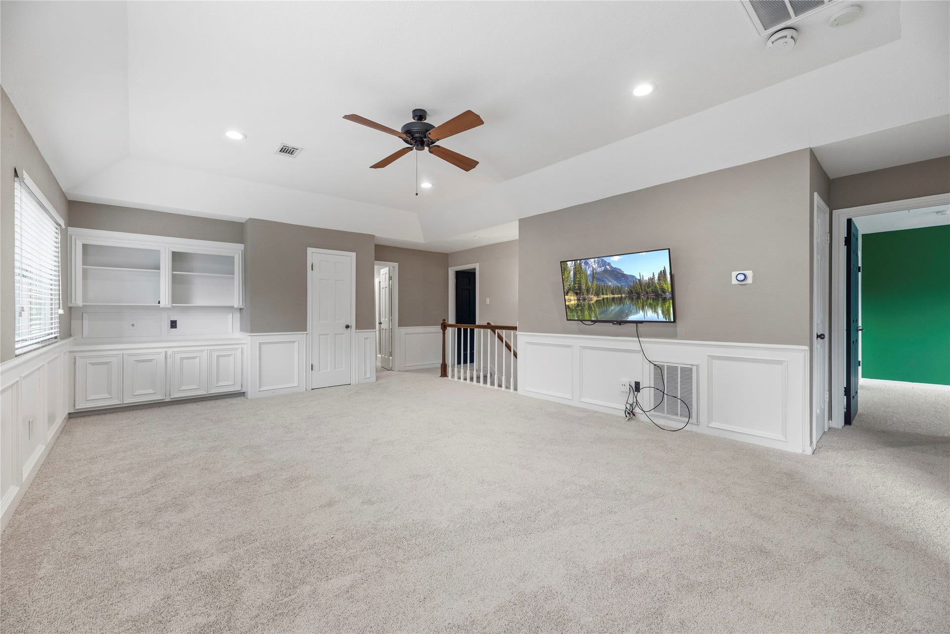Versatile upstairs game room with custom built-ins.