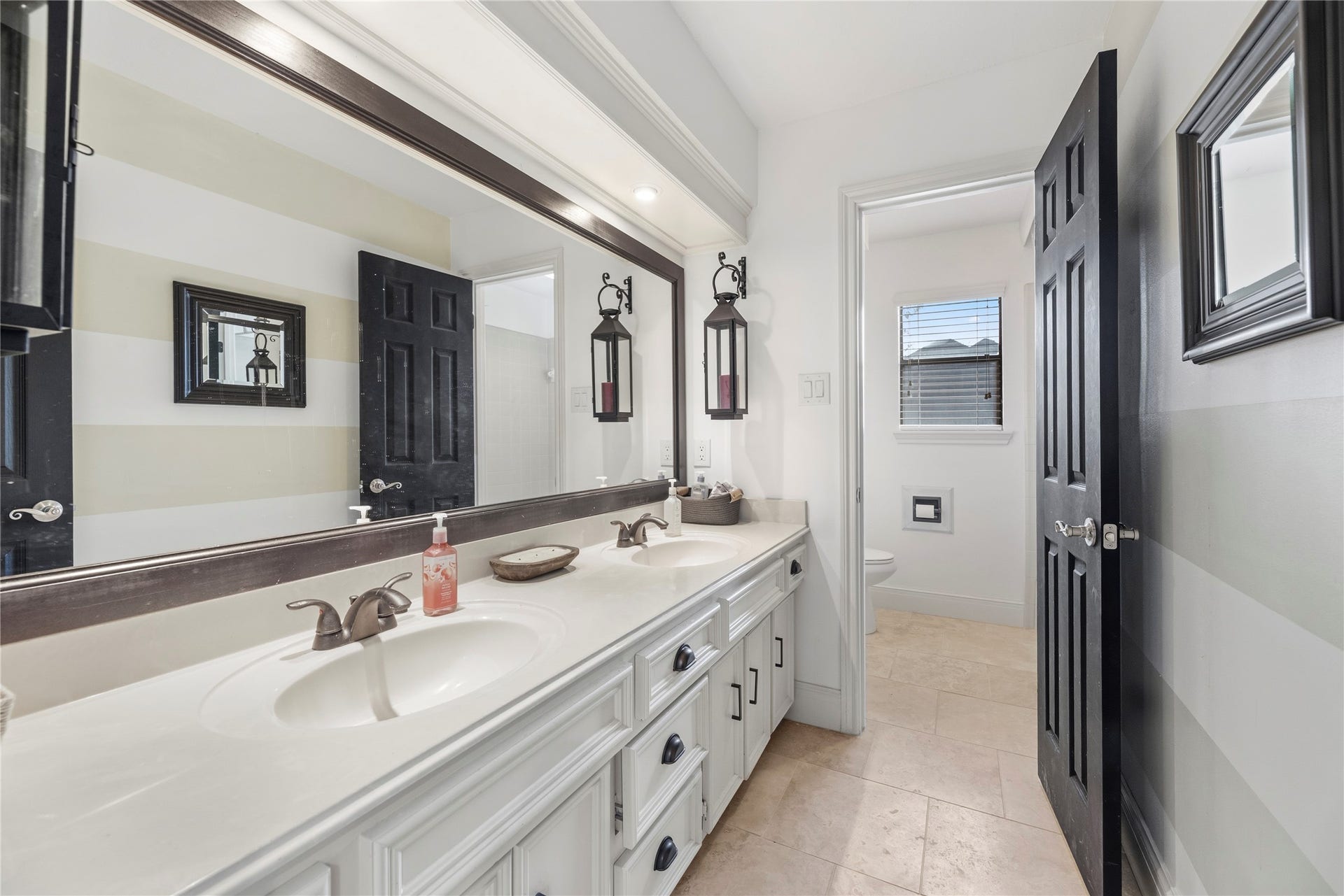 Full upstairs bathroom with a dual sink vanity and tub/shower combination.