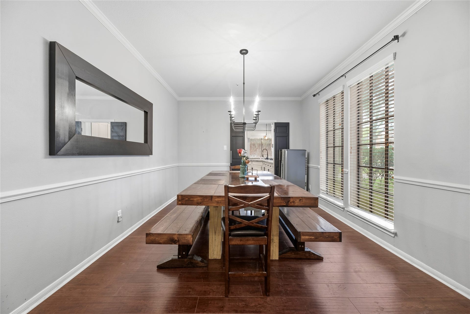 Beautiful formal dining room just off the entry offers wood flooring, crown molding, chair rail and elegant light fixture.