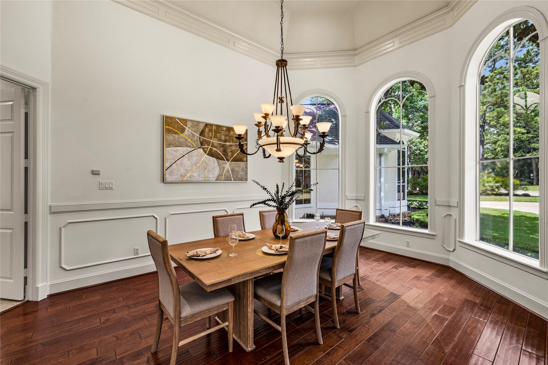 Dining room located off the front of the home with wall of windows, trim moldings, and vaulted ceilings.