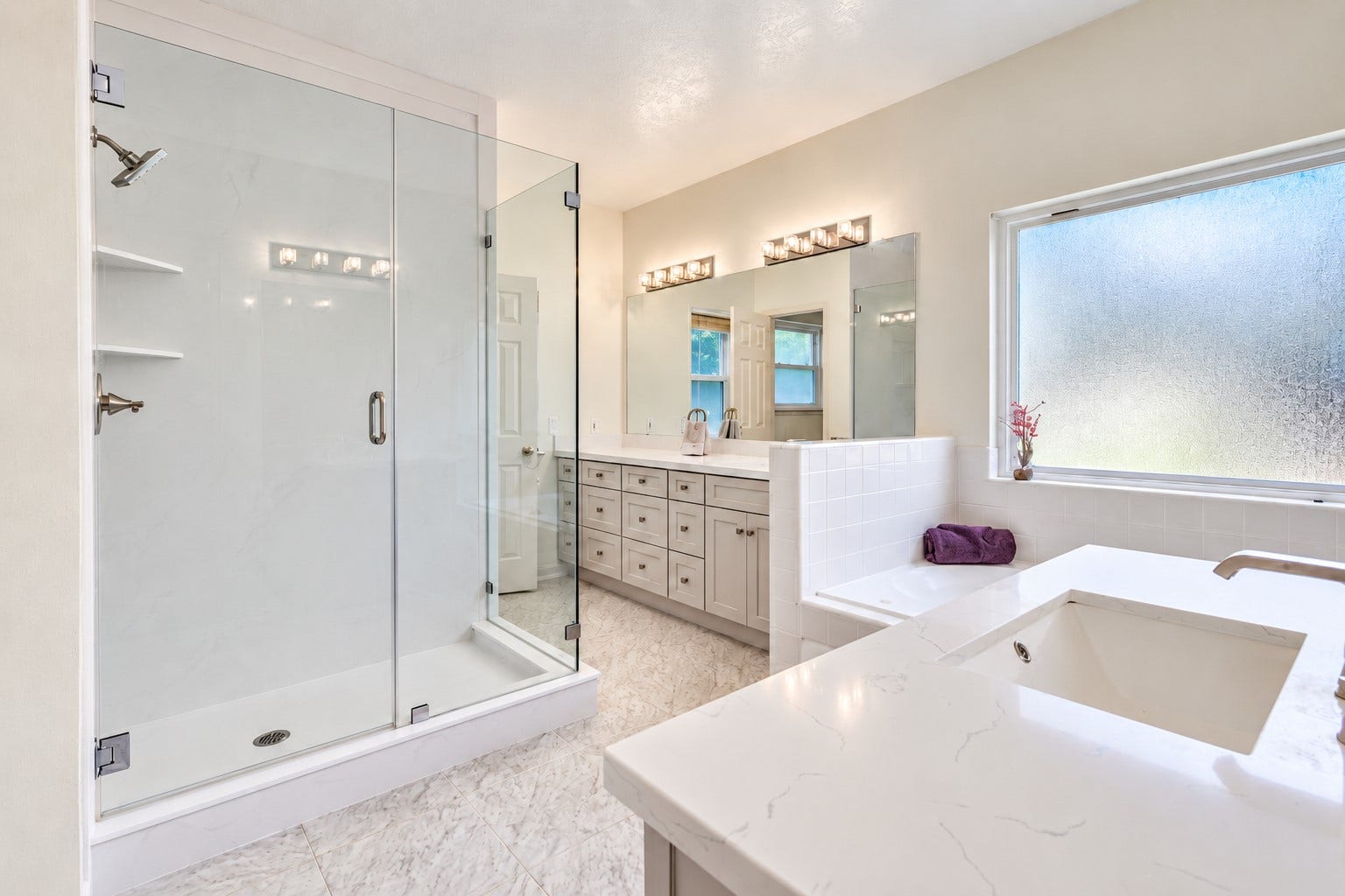 304 Melodywood Drive, Friendswood, TX 77546 The spacious primary bath features a large shower with a frameless glass enclosure, a separate jetted tub, and dual vanities with ample cabinet and drawer storage. Light finishes and a large privacy window create a bright, inviting space to unwind.