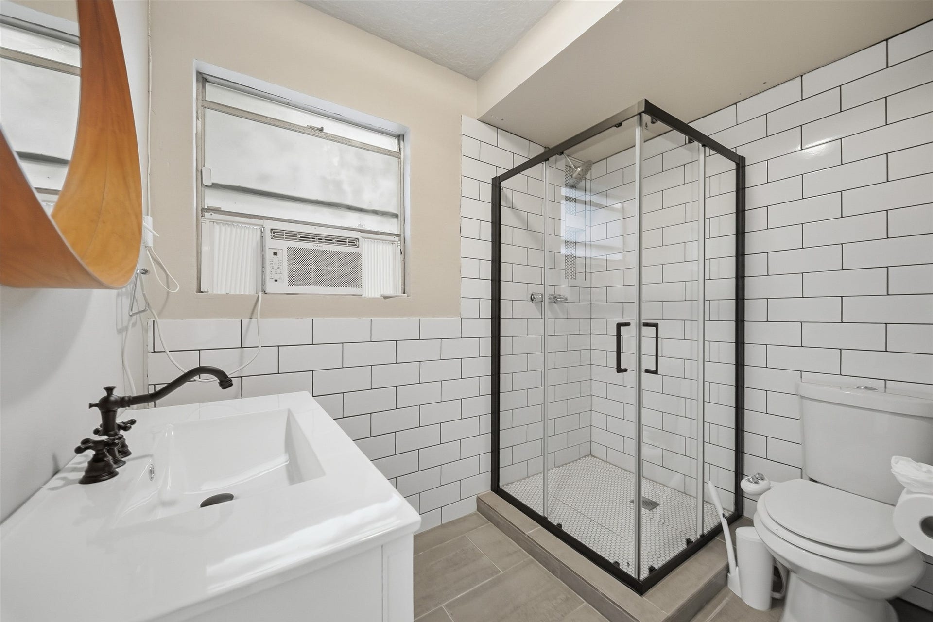 Sleek and modern bathroom featuring a glass-enclosed shower with white subway tile, a stylish vanity, and neutral tones for a clean and inviting atmosphere.