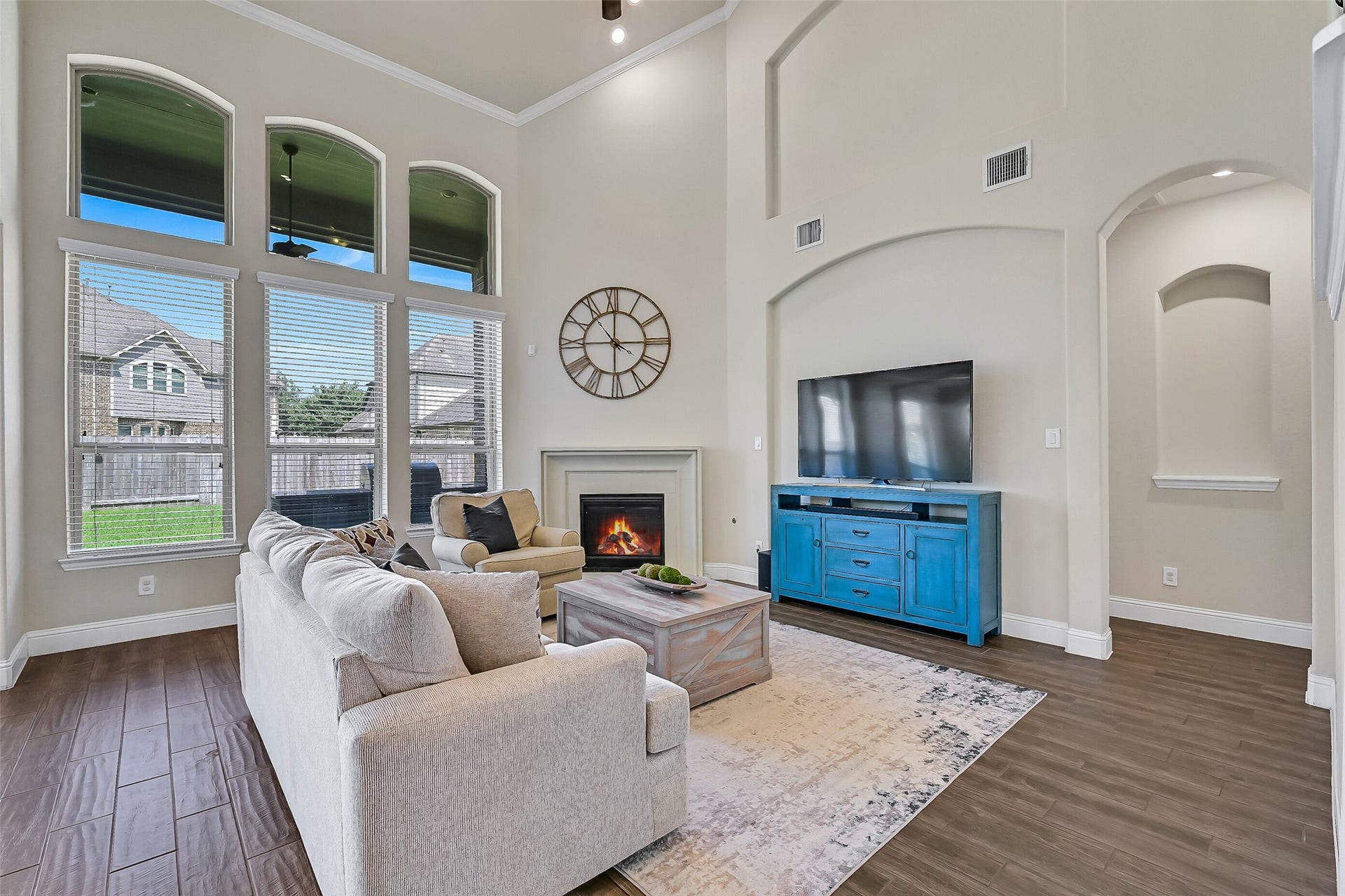 1645 Longwood Glen Lane, Friendswood, TX 77546 Natural light pours through towering windows, highlighting the home's soaring ceilings and spacious layout. Whether enjoying a cozy evening by the fireplace or gathering with friends and family, this inviting living space was designed to bring everyone together.