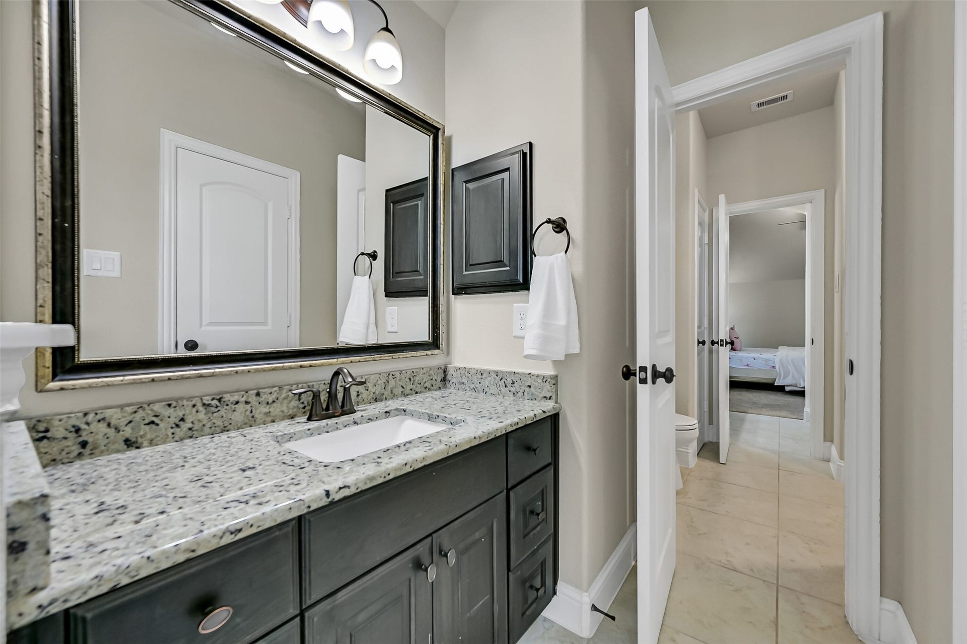 1645 Longwood Glen Lane, Friendswood, TX 77546 Connecting two generously sized secondary bedrooms, this well-appointed bath includes granite countertops, abundant storage, and a private tub and shower area tucked behind a separate doormaking busy mornings more efficient for everyone.