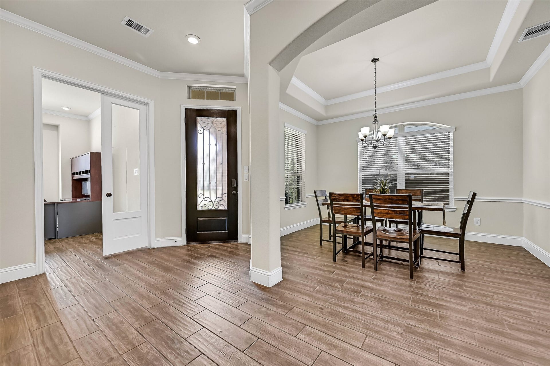 1645 Longwood Glen Lane, Friendswood, TX 77546 Designed with both beauty and function in mind, the foyer is flanked by a private study with French doors and a formal dining room featuring a tray ceiling, crown molding, and an elegant scrolled iron chandelier. The open layout offers an effortless flow into the heart of the home.