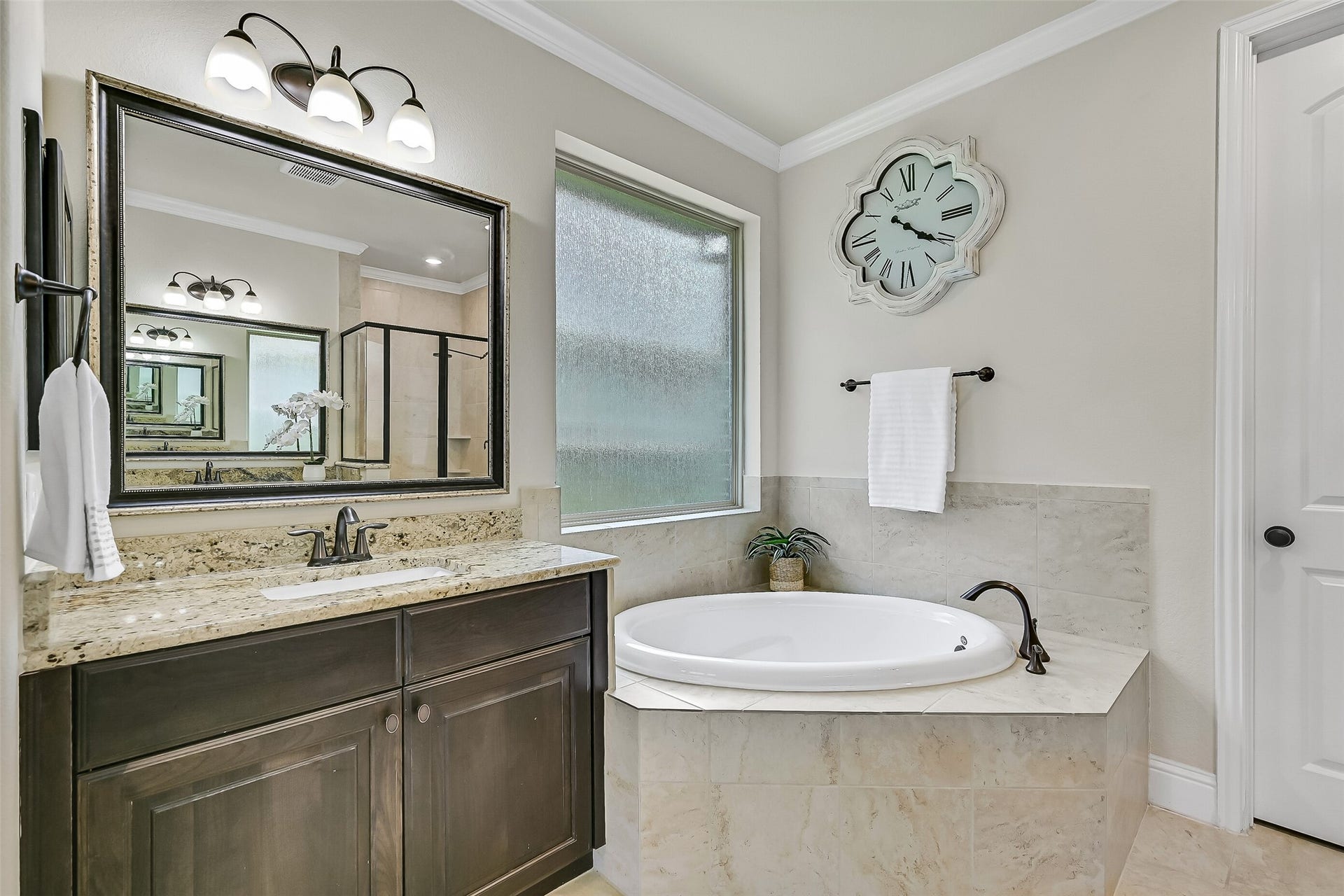 1645 Longwood Glen Lane, Friendswood, TX 77546 A corner soaking tub beneath the frosted window creates the perfect place to unwind, while the thoughtful layout offers plenty of space to spread out during busy mornings. Every detail balances everyday functionality with a touch of luxury.