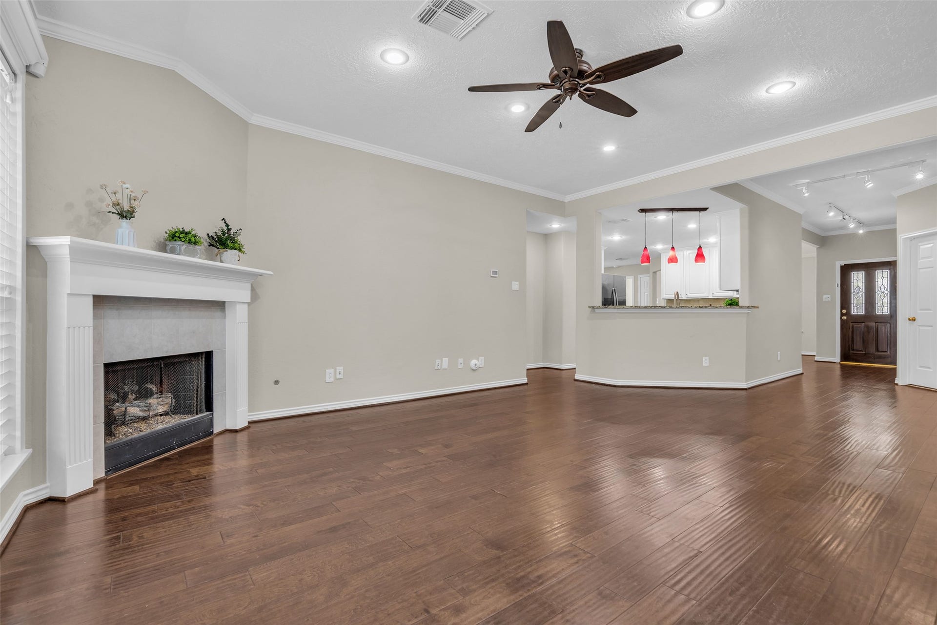 14 Almond Branch Place, The Woodlands, TX 77382 Living area offers hard flooring, gas fireplace, crown molding, neutral colors, and ample lighting.