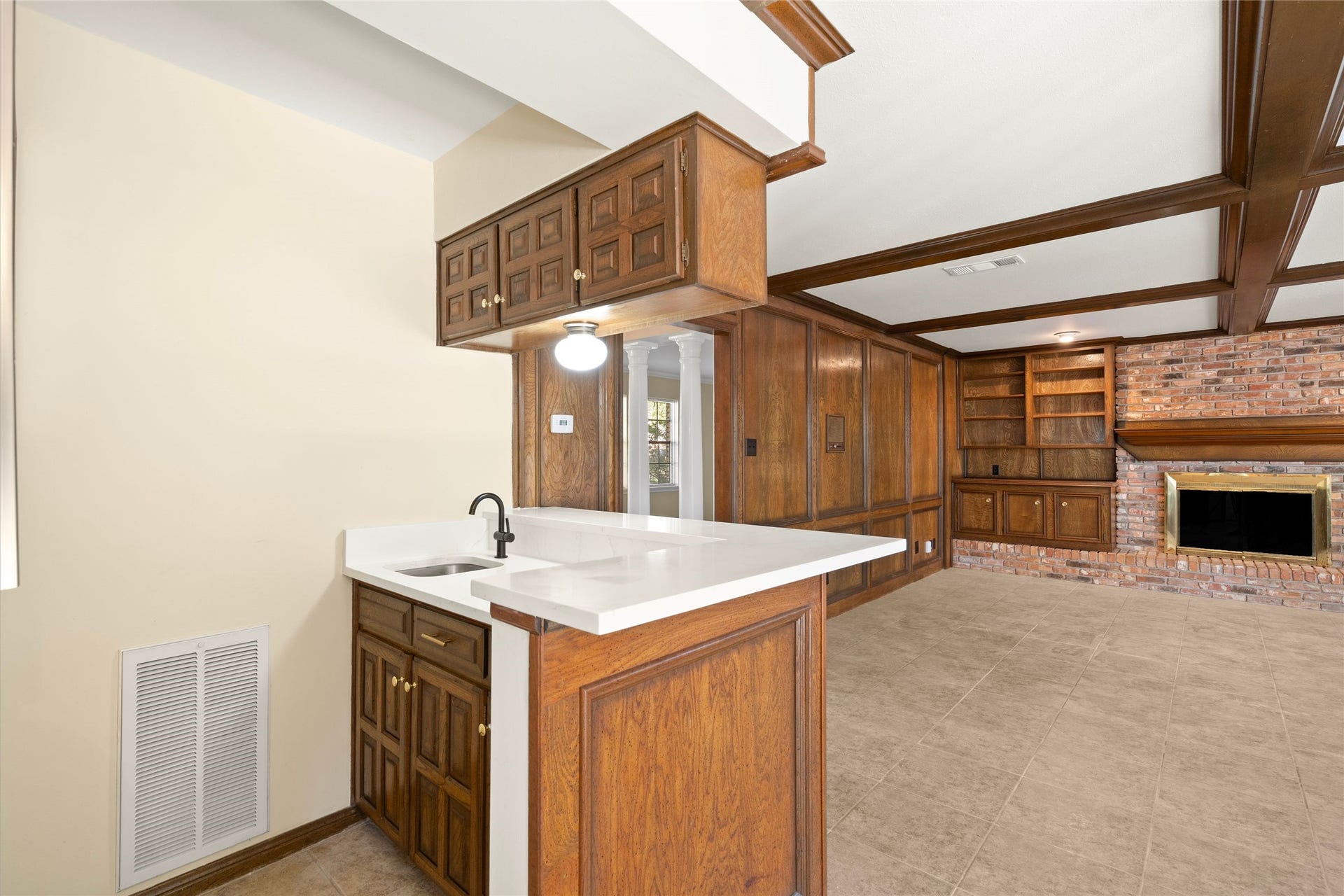 Wet bar with storage above and below also showcasing new fixtures and quartz countertops.