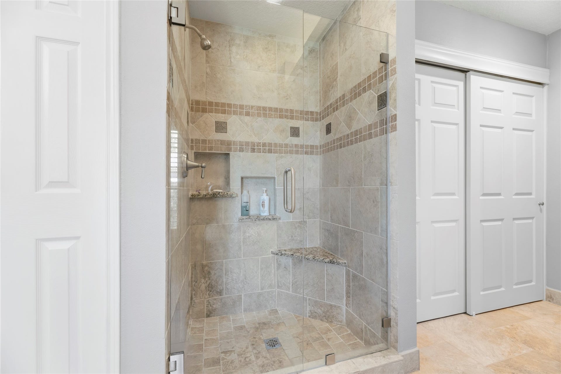 17906 Lone River Court, Houston, TX 77095 Frameless shower with a bench.
