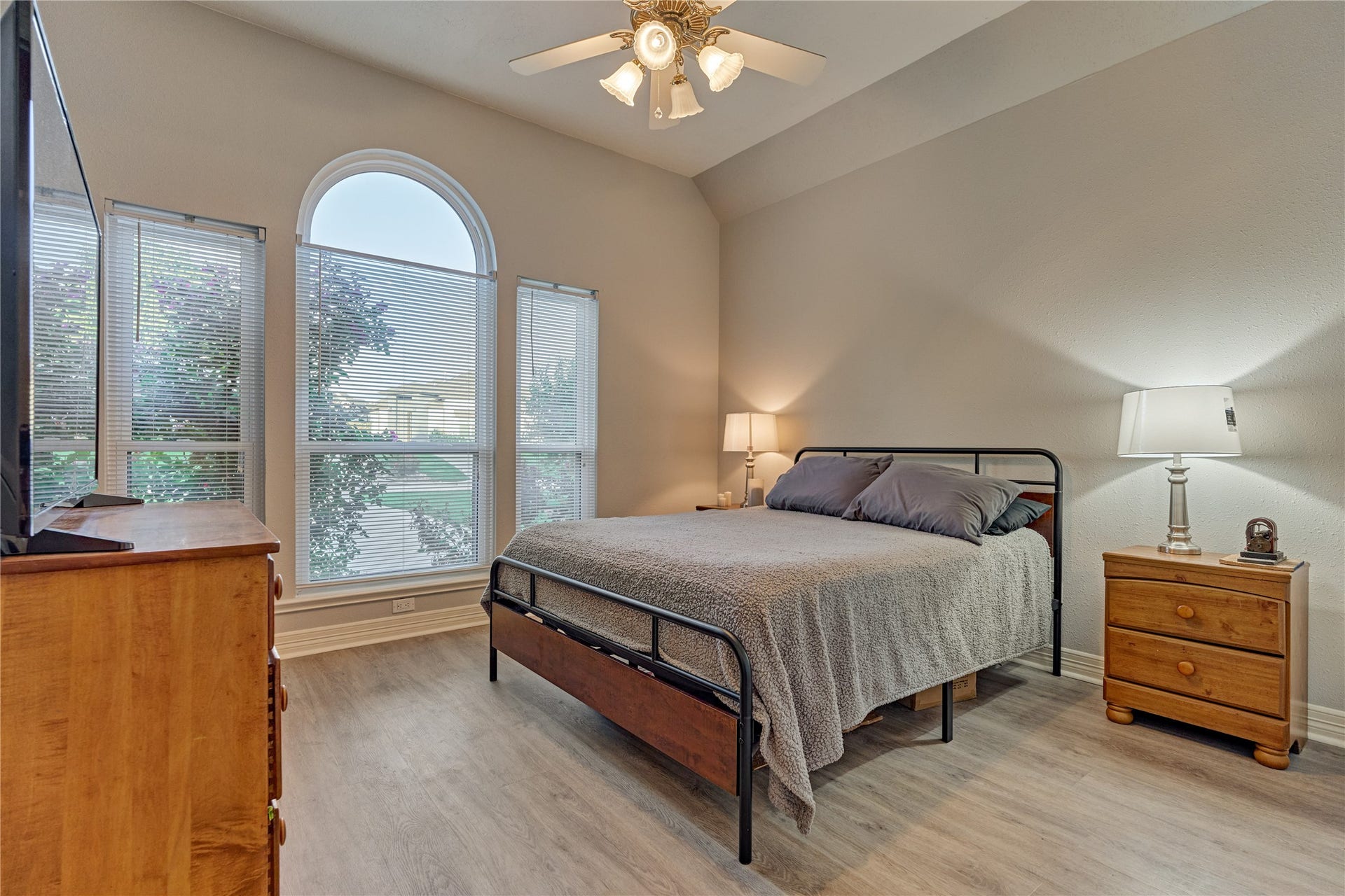 15 Newberry Court, Montgomery, TX 77356 Secondary bedroom #1 features updated flooring, high ceilings, and a wall-of-windows that overlook the front yard and fills the space with abundant natural light.