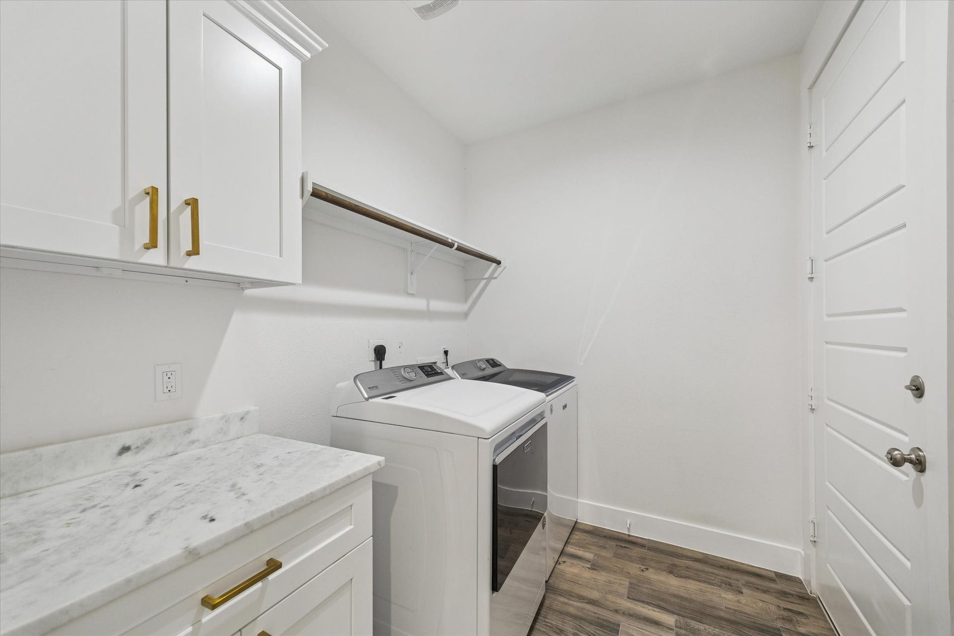This utility/laundry room is both spacious and refined, featuring beautiful marble surfaces along with ample storage and counter space, perfect for organizing cleaning products, folding laundry, and hanging delicate items. Thoughtfully designed, it provides everything a family needs while maintaining a clean, polished, and functional environment.