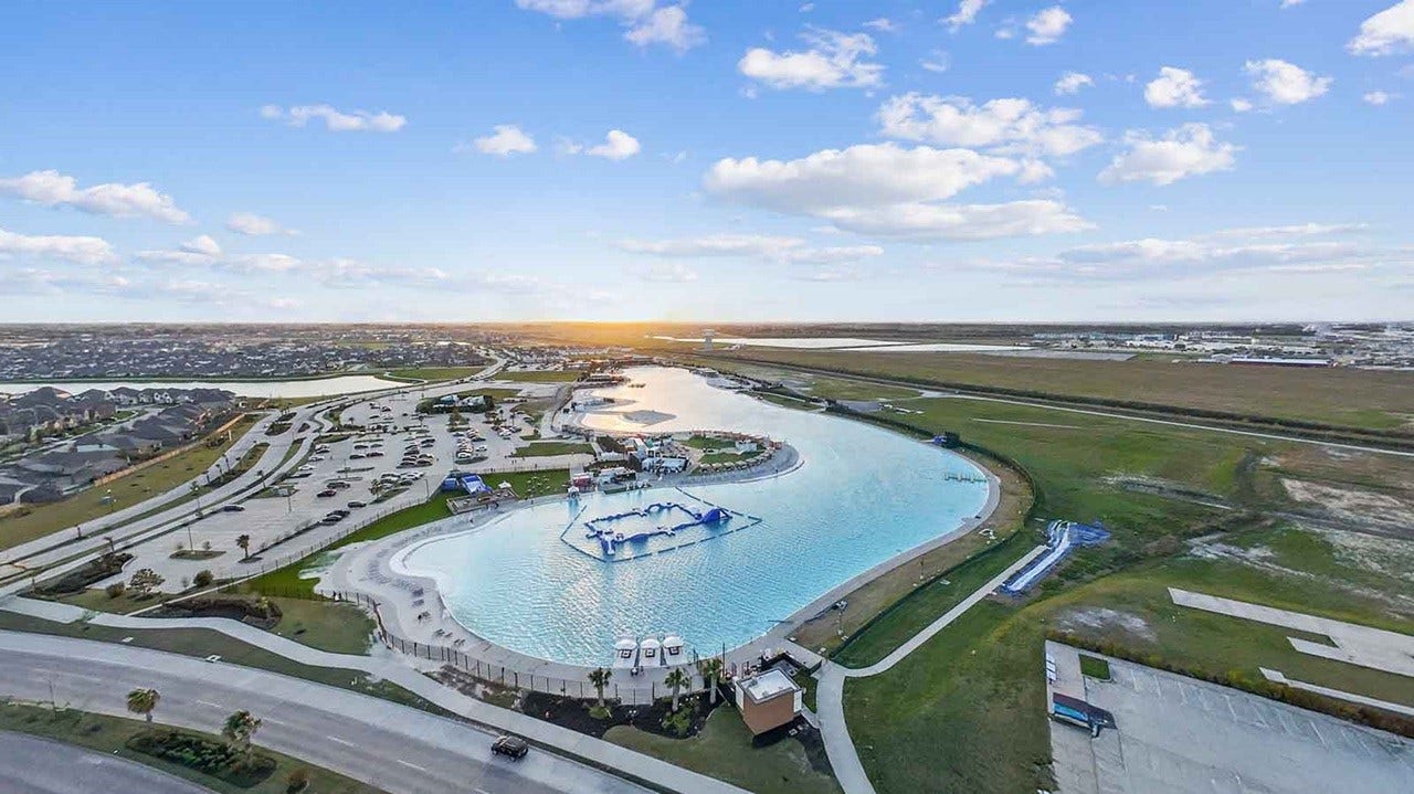 13021 Sapphire Lake Lane, La Marque, TX 77568 Aerial view of the communities crystal lagoon with sandy beaches and waterfront recreation