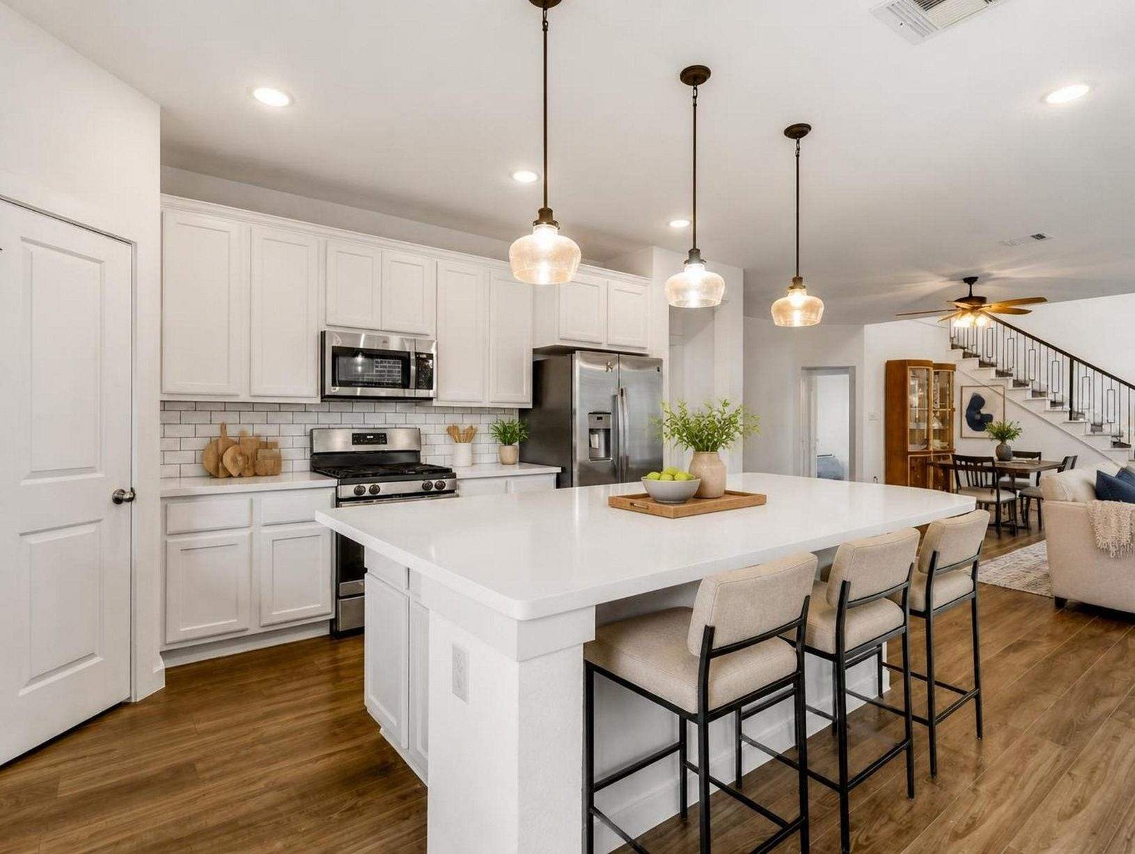 13021 Sapphire Lake Lane, La Marque, TX 77568 The kitchen brings together quartz counters, a large island, stainless appliances, and pendant lighting. A bright central space with a luxury everyday feel. Virtually staged.