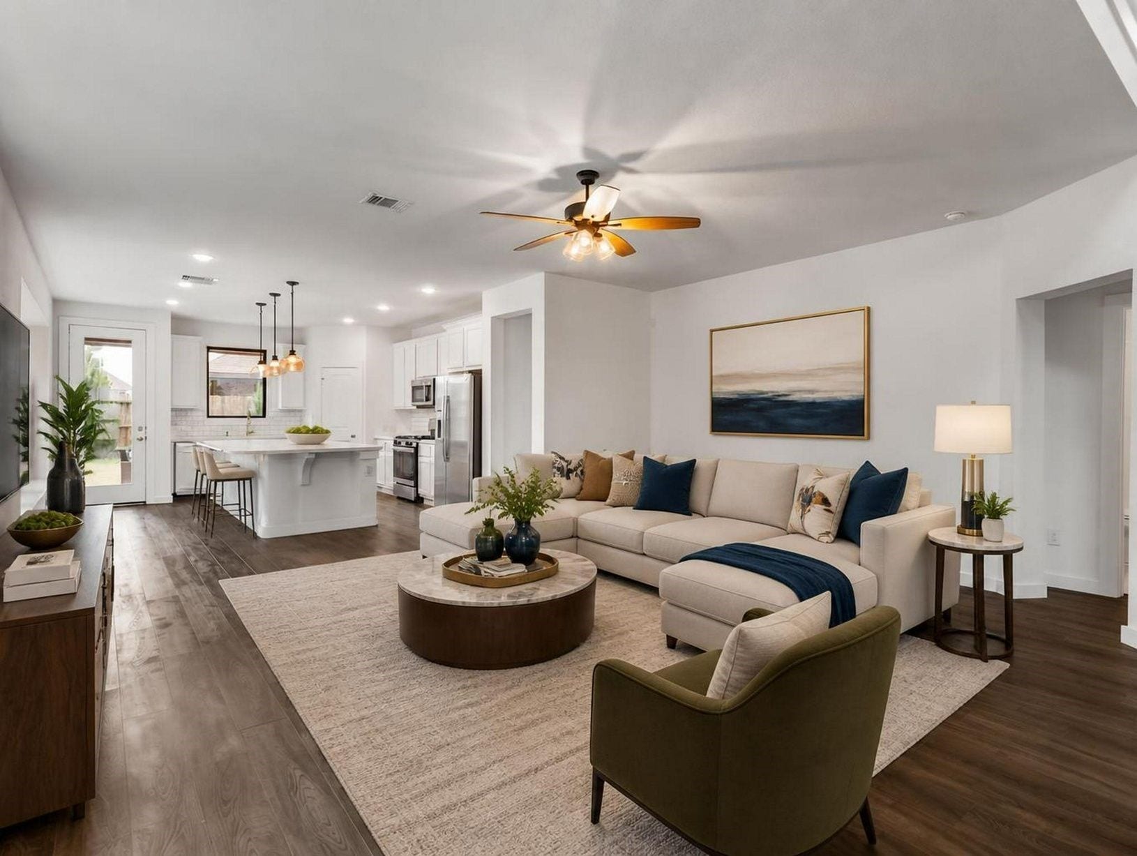 13021 Sapphire Lake Lane, La Marque, TX 77568 The living room flows directly into the kitchen, creating one open and connected main level. Warm floors and natural light give the space a composed feel. Virtually staged.