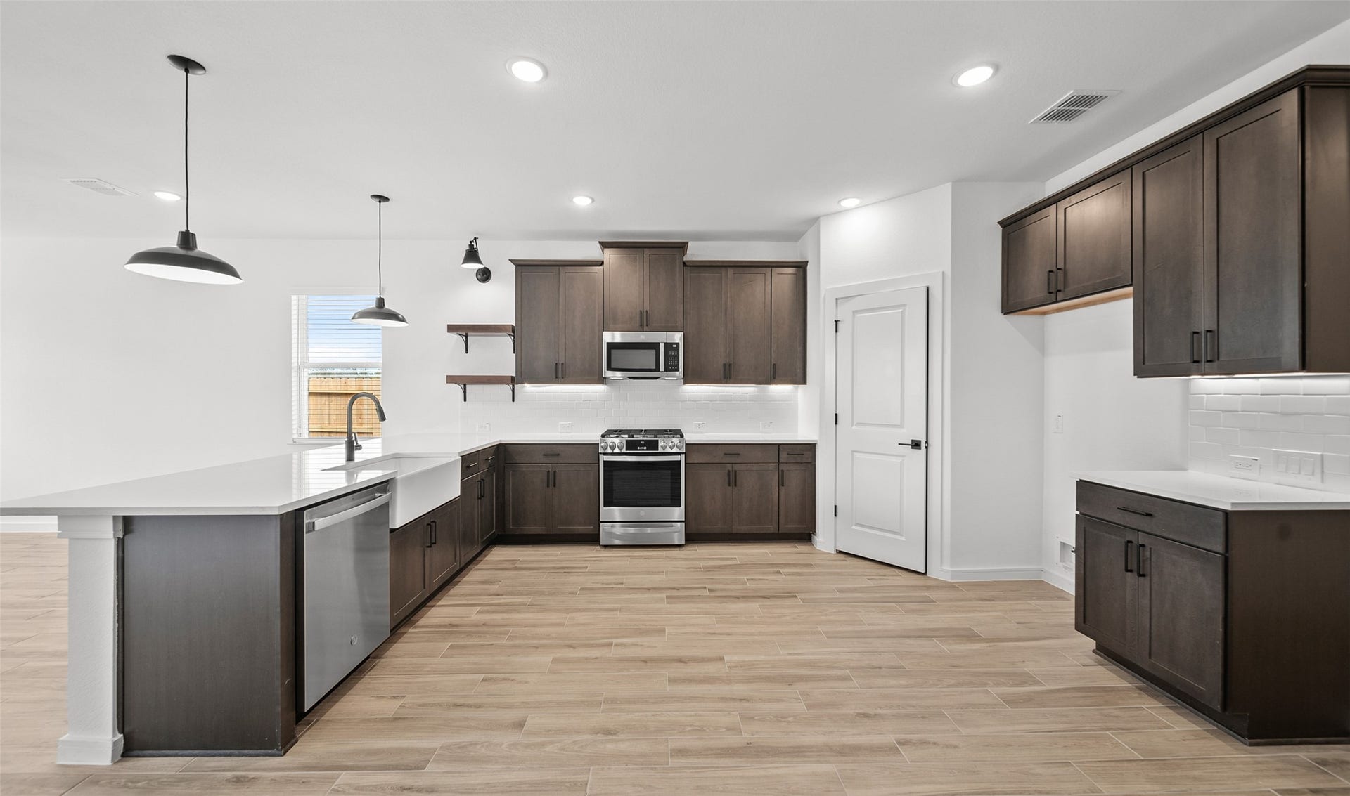 655 Daniels Lake Lane, Dayton, TX 77535 Lovely kitchen with dark stain cabinets and floating shelves (*Photo not of actual home and used for illustration purposes only.)
