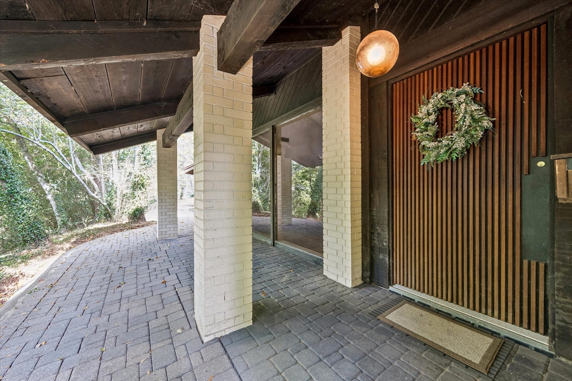 104 Gershwin Drive, Houston, TX 77079 Welcoming front entrance showcases a striking oversized cypress wood door, accented by brick columns, exposed wood beams & a spacious covered entry.